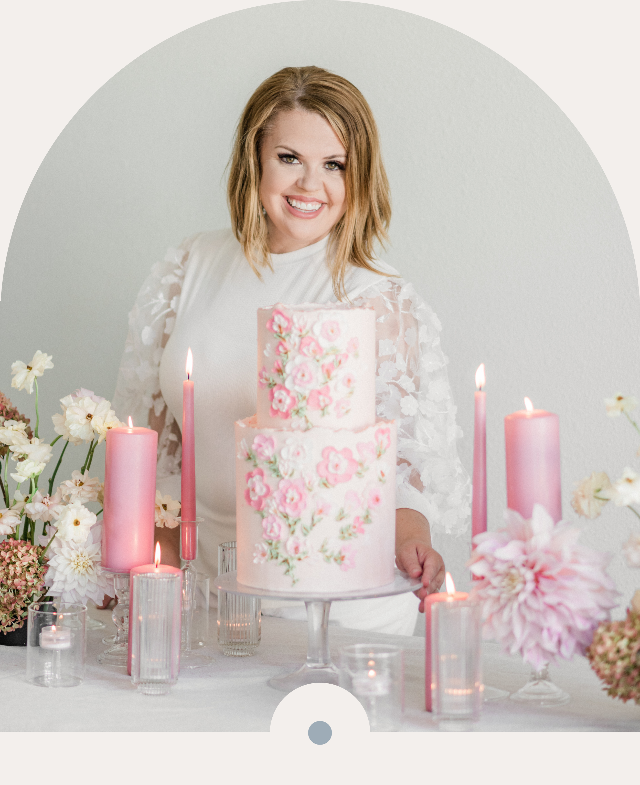 Virtual Assistant to Wedding Pros Lori Losee at a wedding cake table complete with a floral cake and pink candles and flowers.