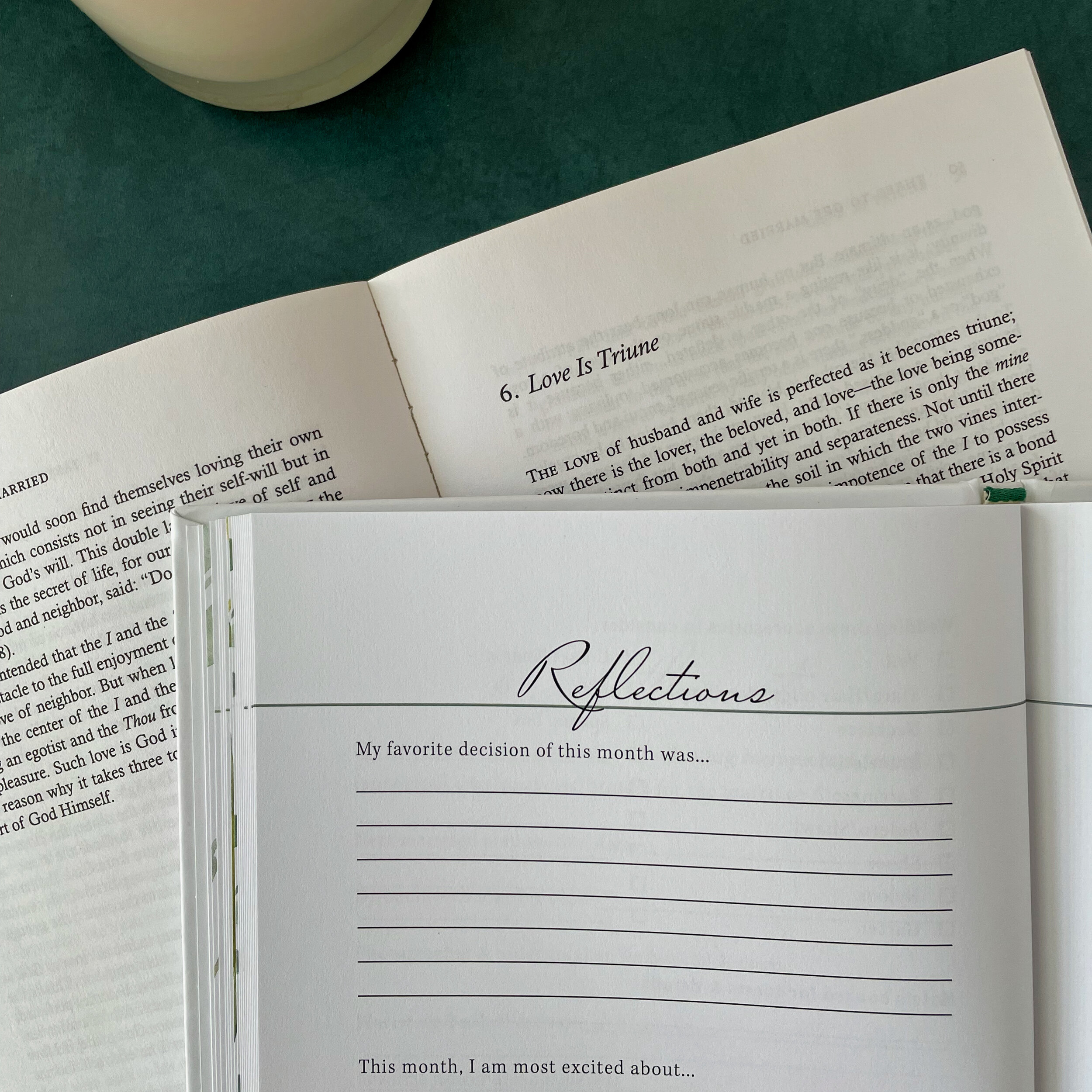 Covenant Wedding Planner page titled "Reflections" with prompts and lines for writing. It is laid on top of Fulton Sheen's "Three to Get Married," opened to the chapter "Love is Triune."