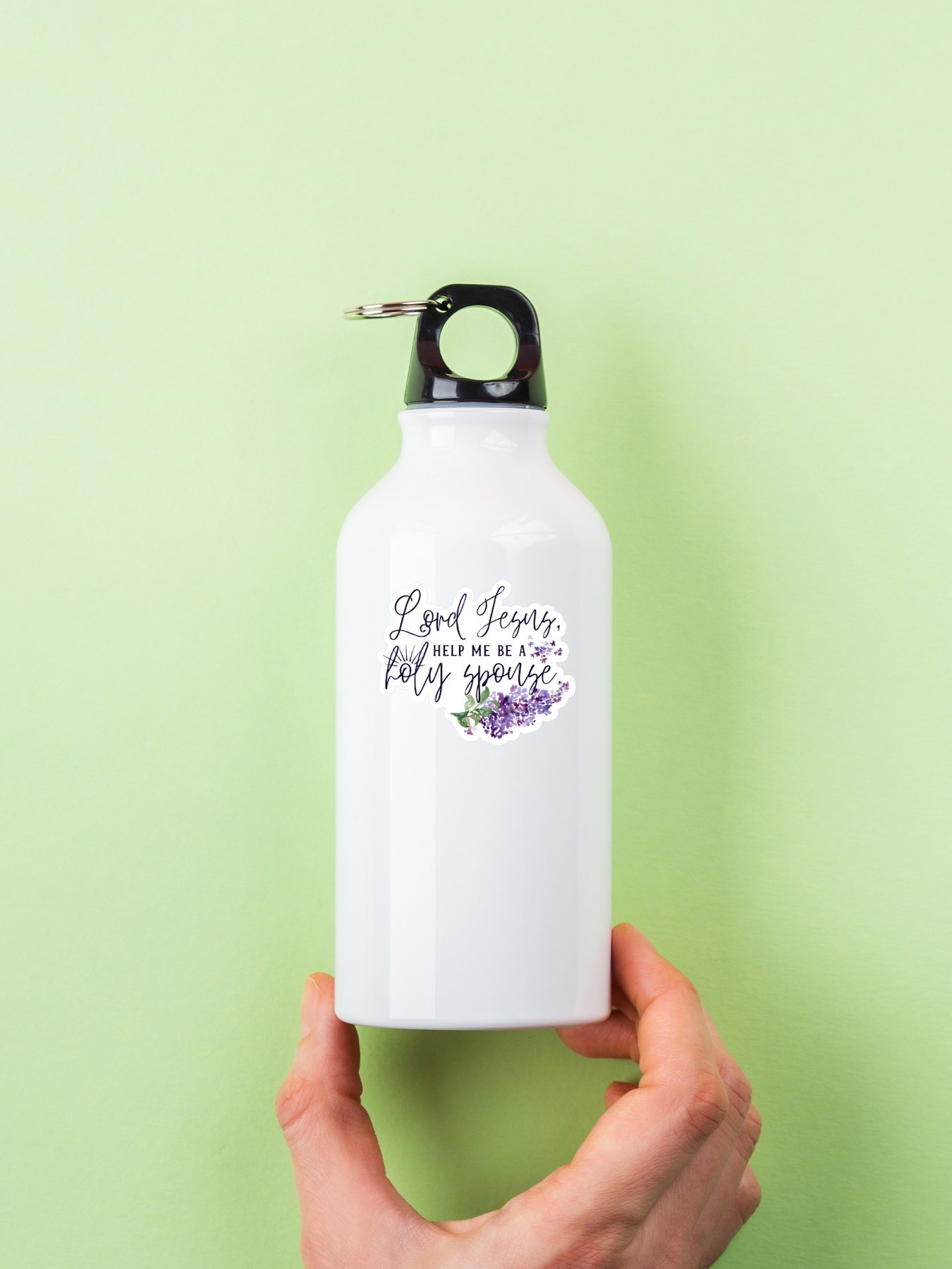 Sticker on metal reusable water bottle. Sticker features purple lilacs with the text "Lord Jesus, help me be a holy spouse" overlayed in calligraphy.