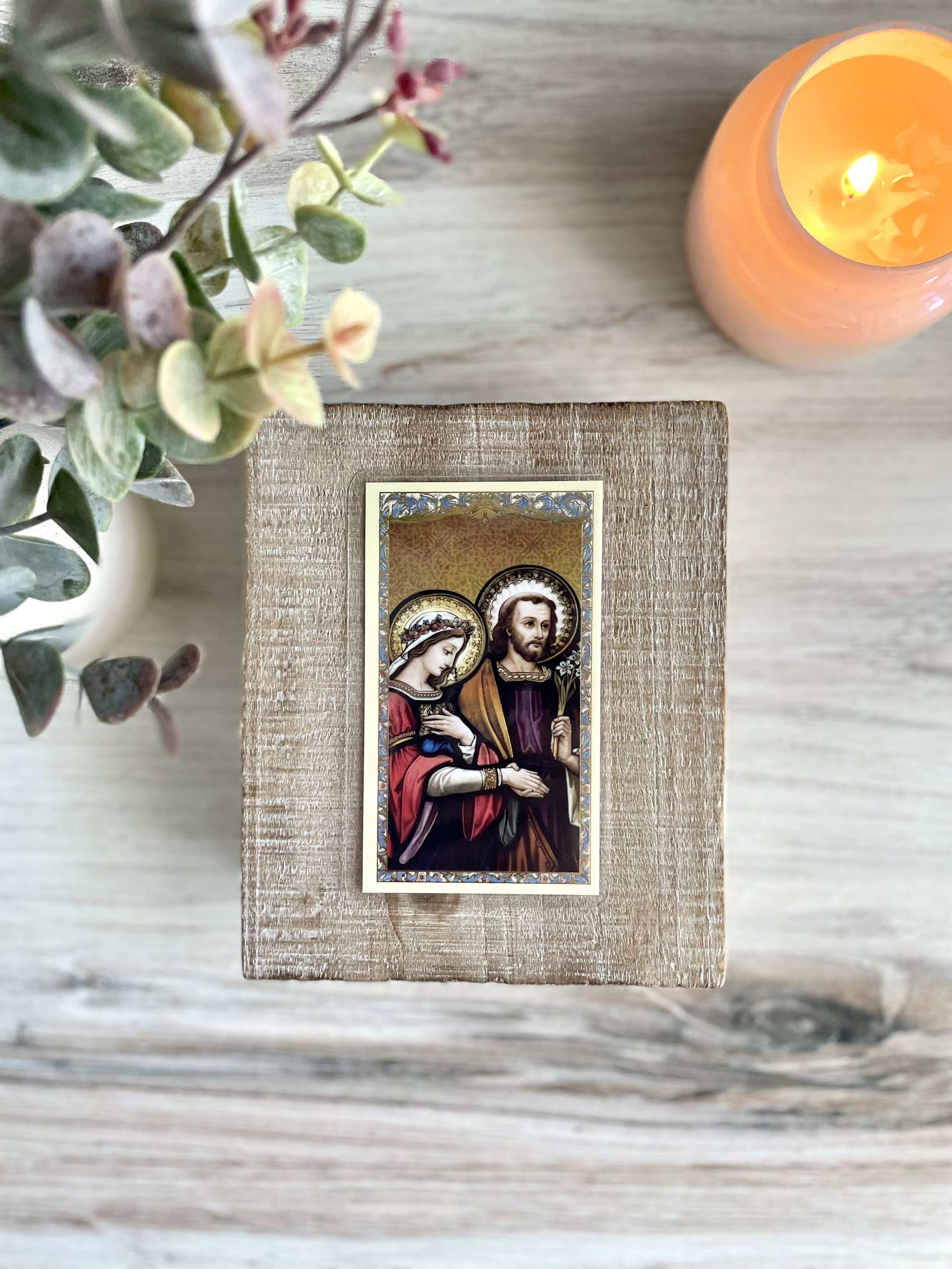 Prayer card features an image of Mary and Joseph on their wedding day. Both have halos around their heads. Joseph is holding a lily stem. Their right hands are clasped together.