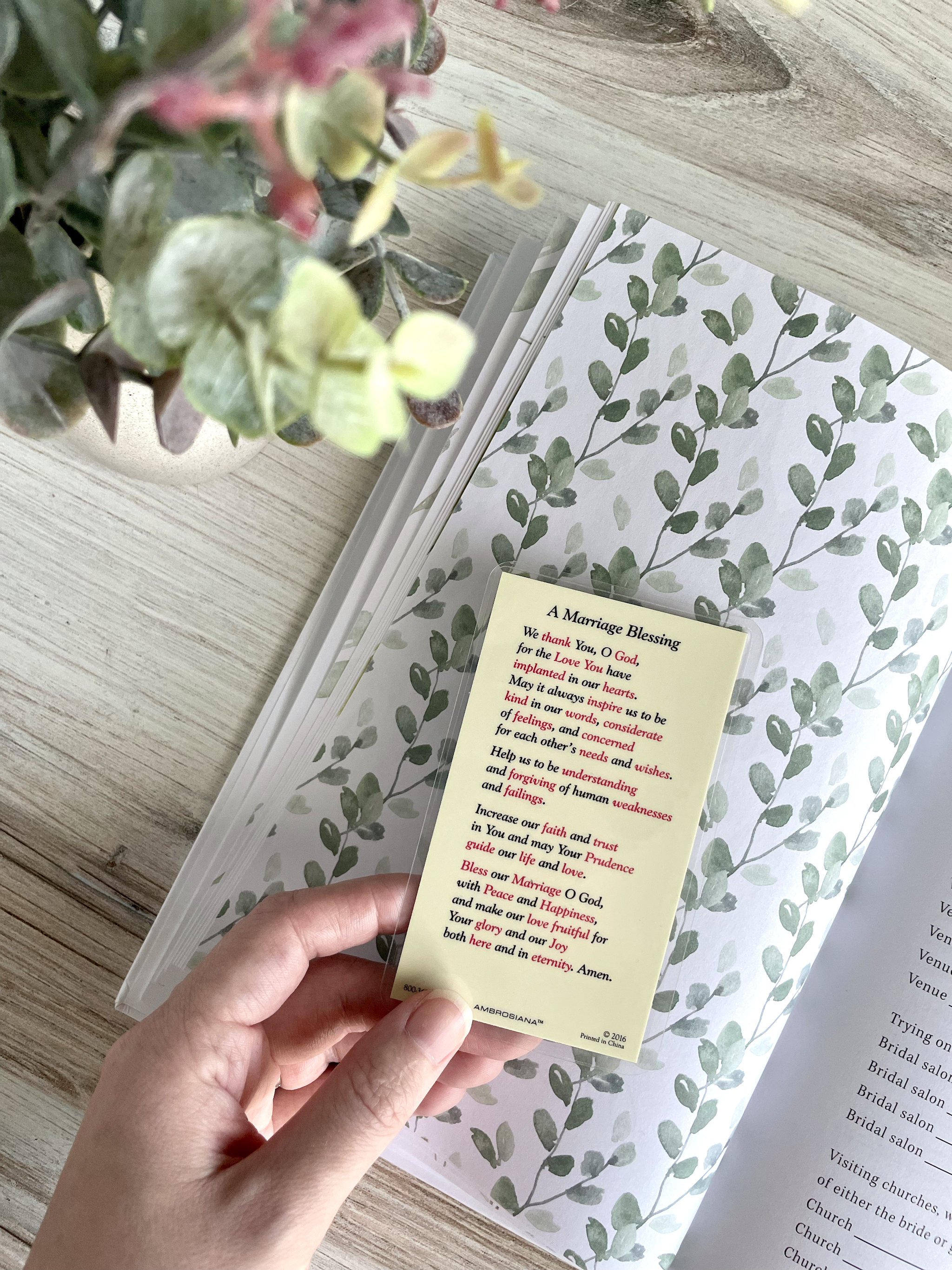 The backside of the Marriage Blessing Prayer card displays the full prayer, which praises God and asks for increase in virtue. The Covenant Wedding Planner is in the background.