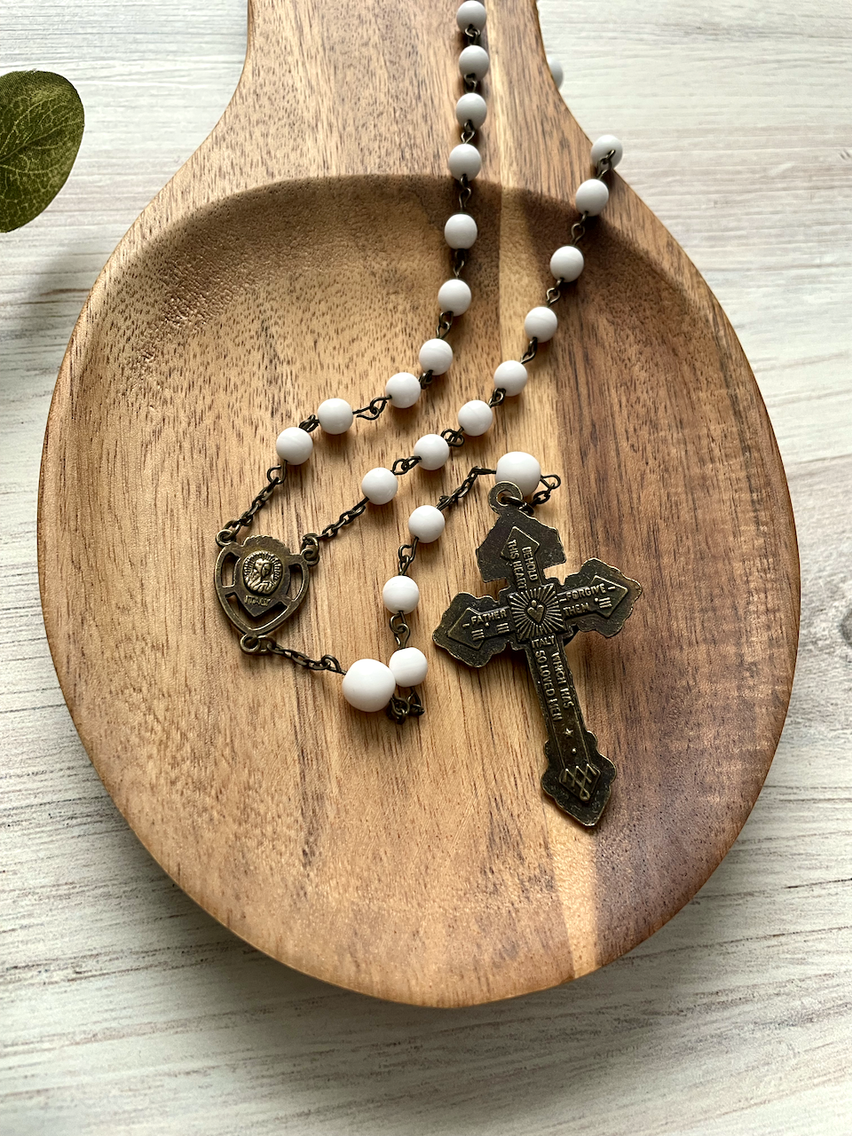 Smooth white beaded rosary with bronze chain links. Bronze pardon crucifix and bronze Sacred Heart centerpiece.