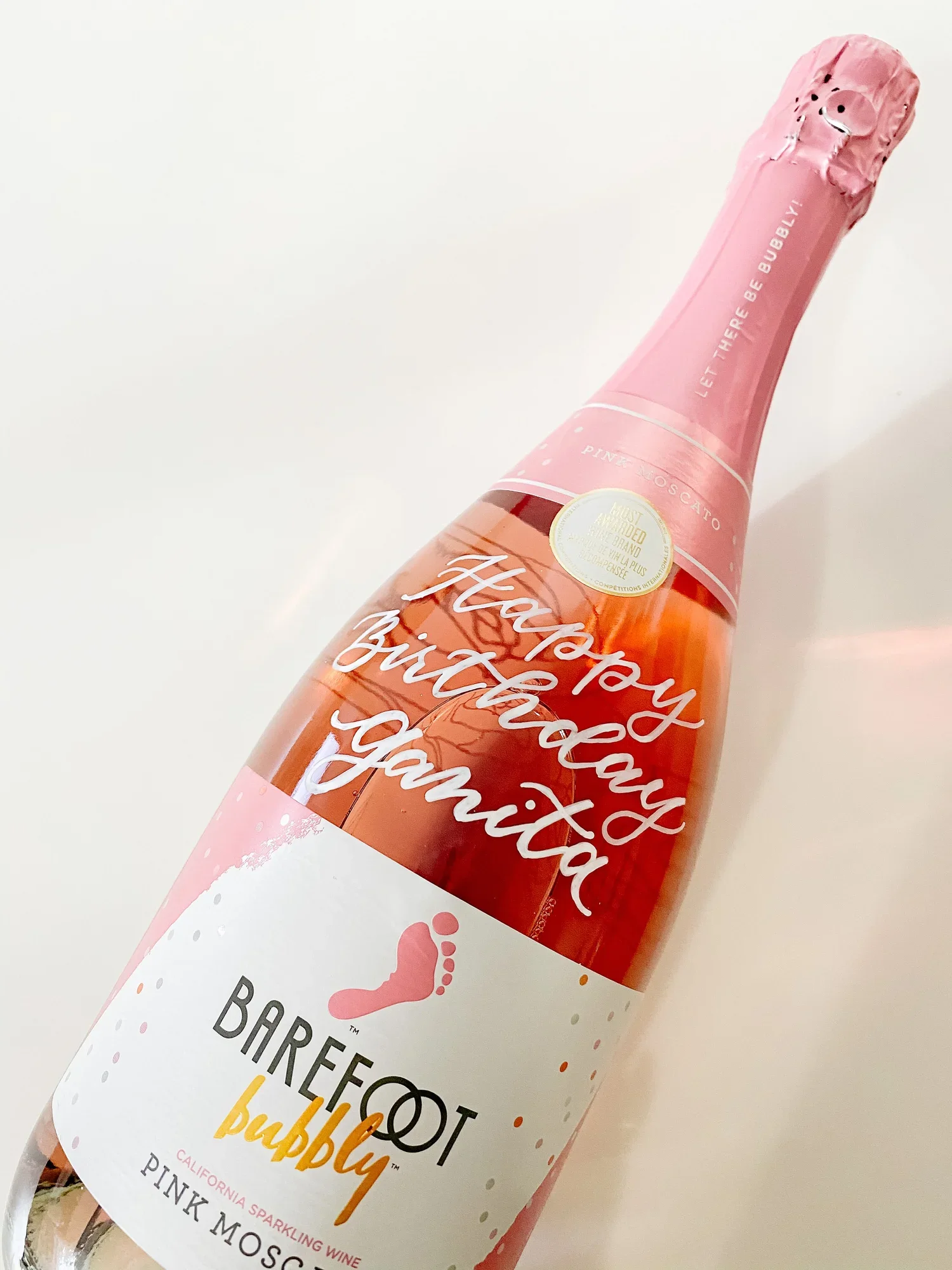 A pink bottle of Barefoot Bubbly Pink Moscato sparkling wine with a label that reads 'Happy Birthday Gamito' and a pink foil top.