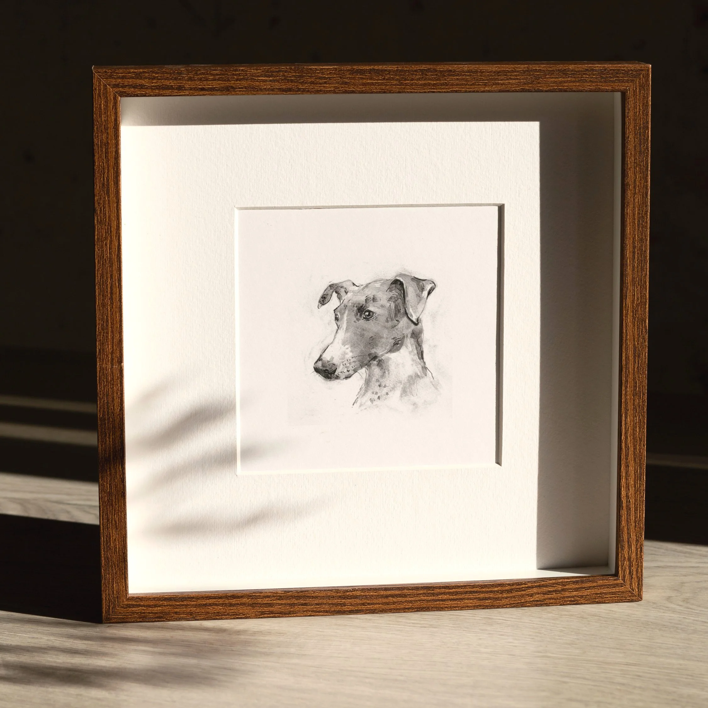 Framed black and white pencil sketch of a terrier dog on white background with wooden border.