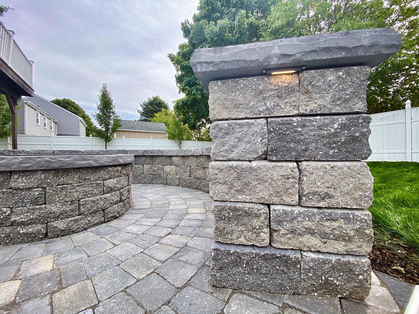 A little lighting goes a long way💡 Custom design to incorporate grey toned pavers and bluestone caps in this fire pit and sitting wall with ambiance lighting install.