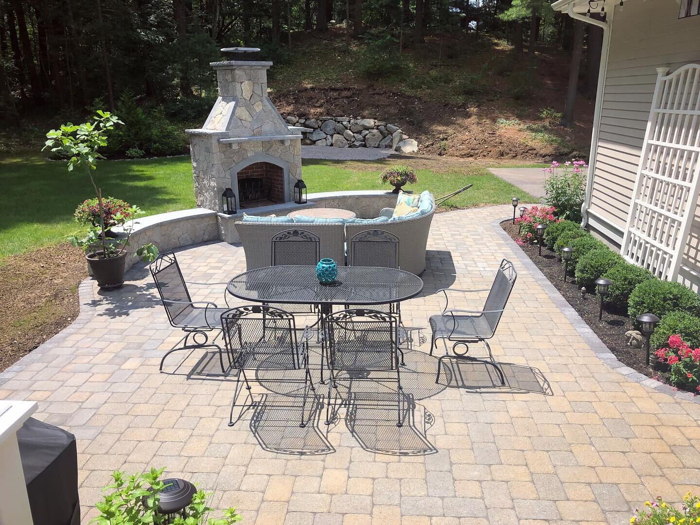 Staying home isn&rsquo;t so bad with this back yard update. Stone pizza oven with sitting wall and large paver patio with garden bed.