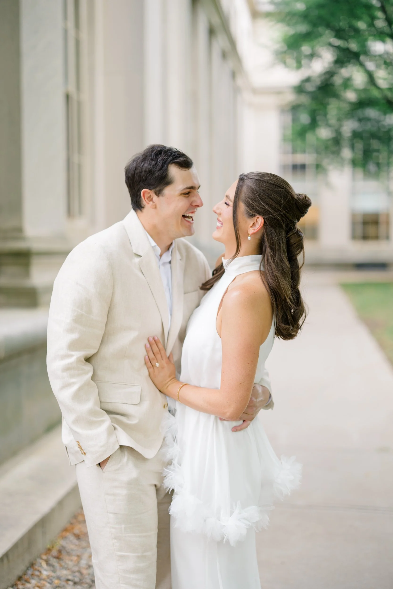 Couple beneath grand marble columns during a timeless Cambridge engagement session.