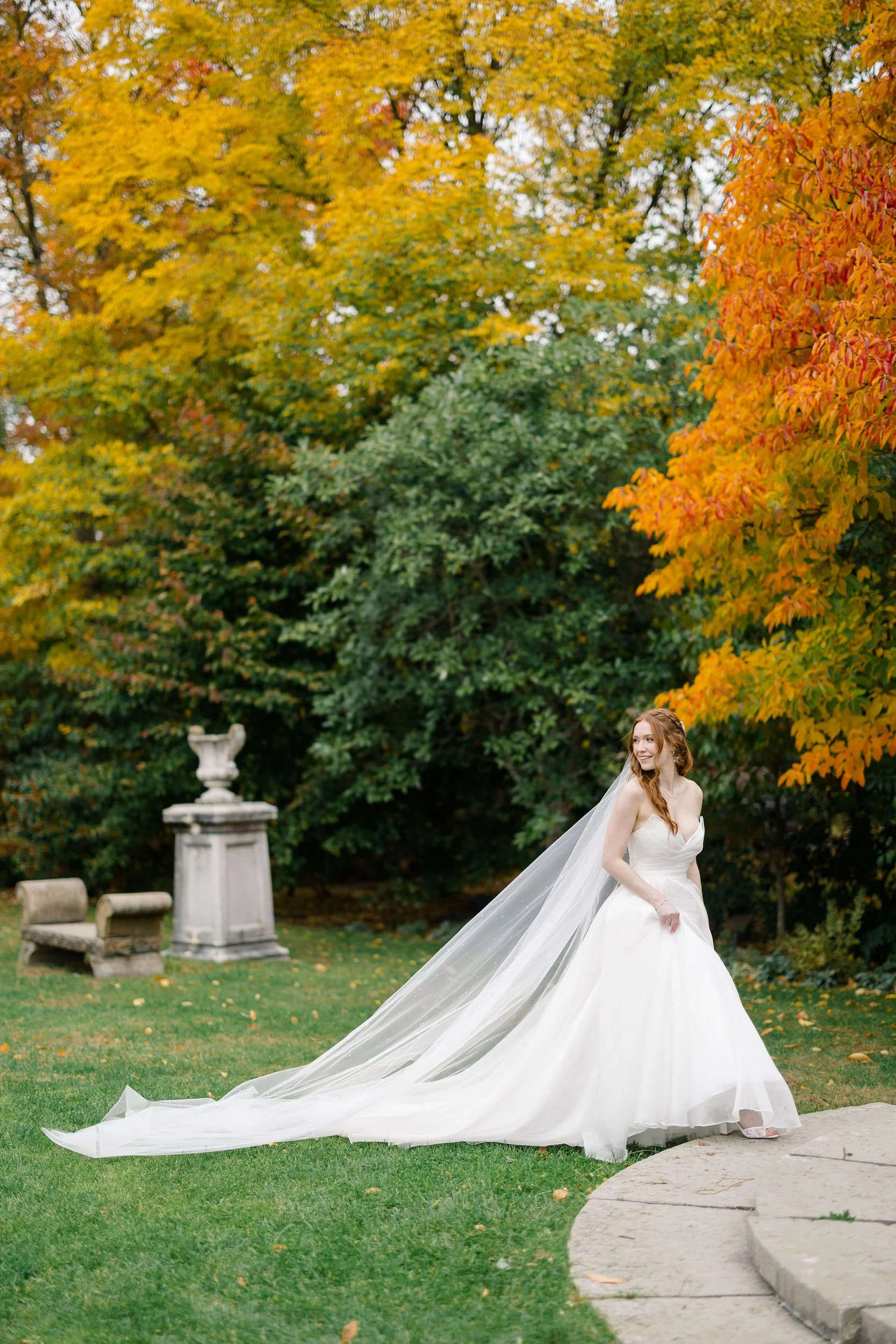 Bride photographed among autumn foliage at Elm Bank Gardens in Wellesley, Massachusetts.