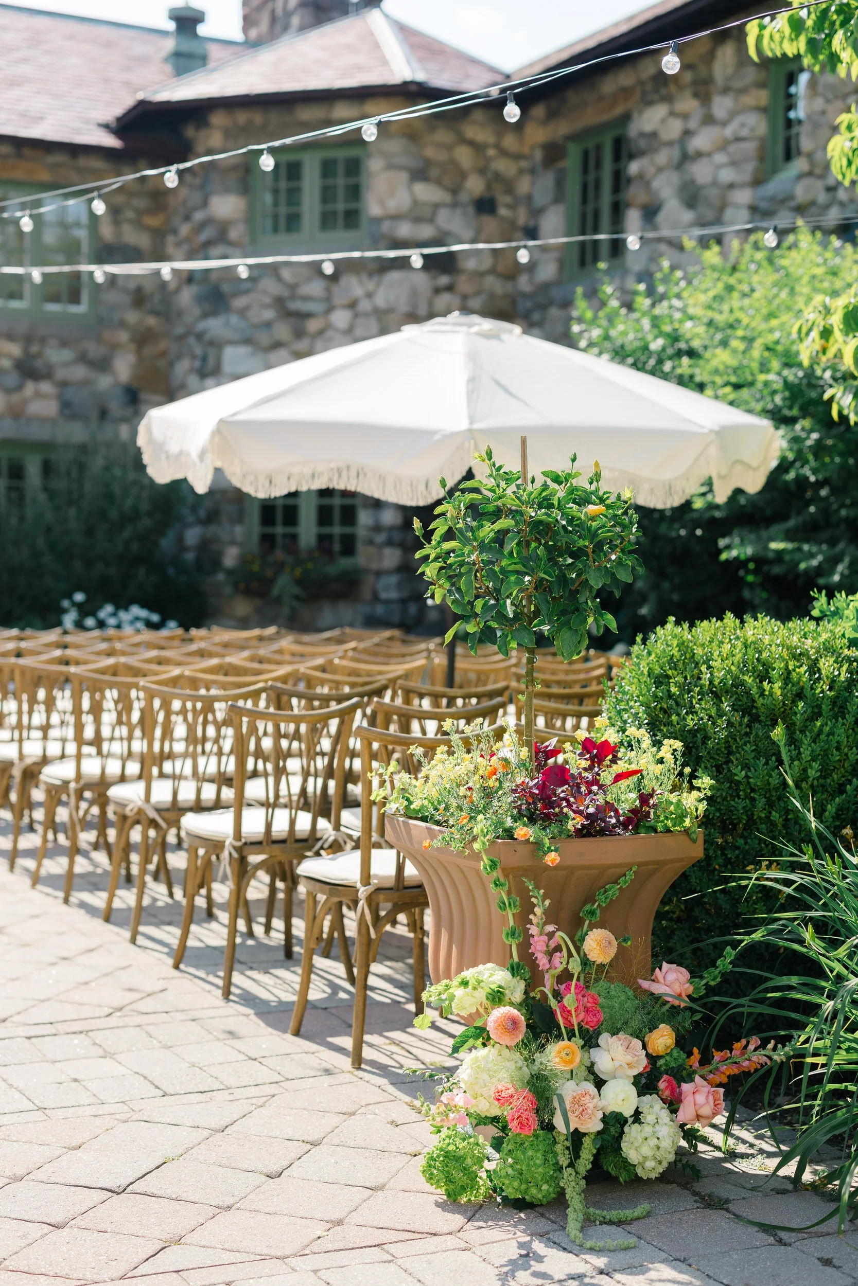 Ceremony floral arrangements featuring pink and orange orchids and dahlias at Willowdale Estate wedding