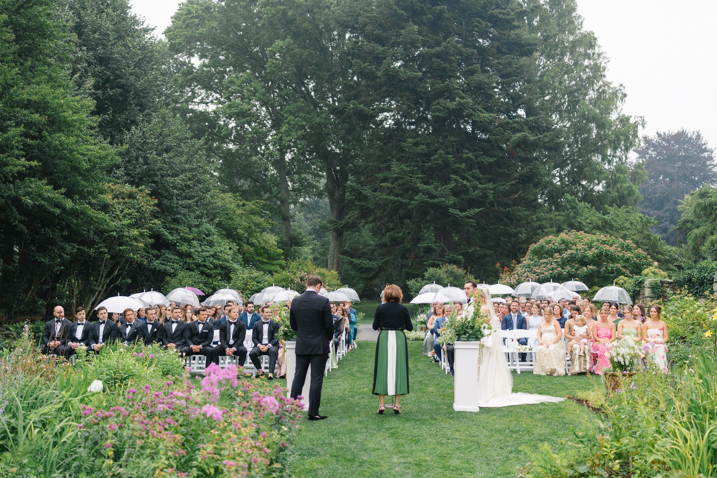 Rainy Blithewold Wedding ceremony surrounded by colorful wildflower-inspired florals.