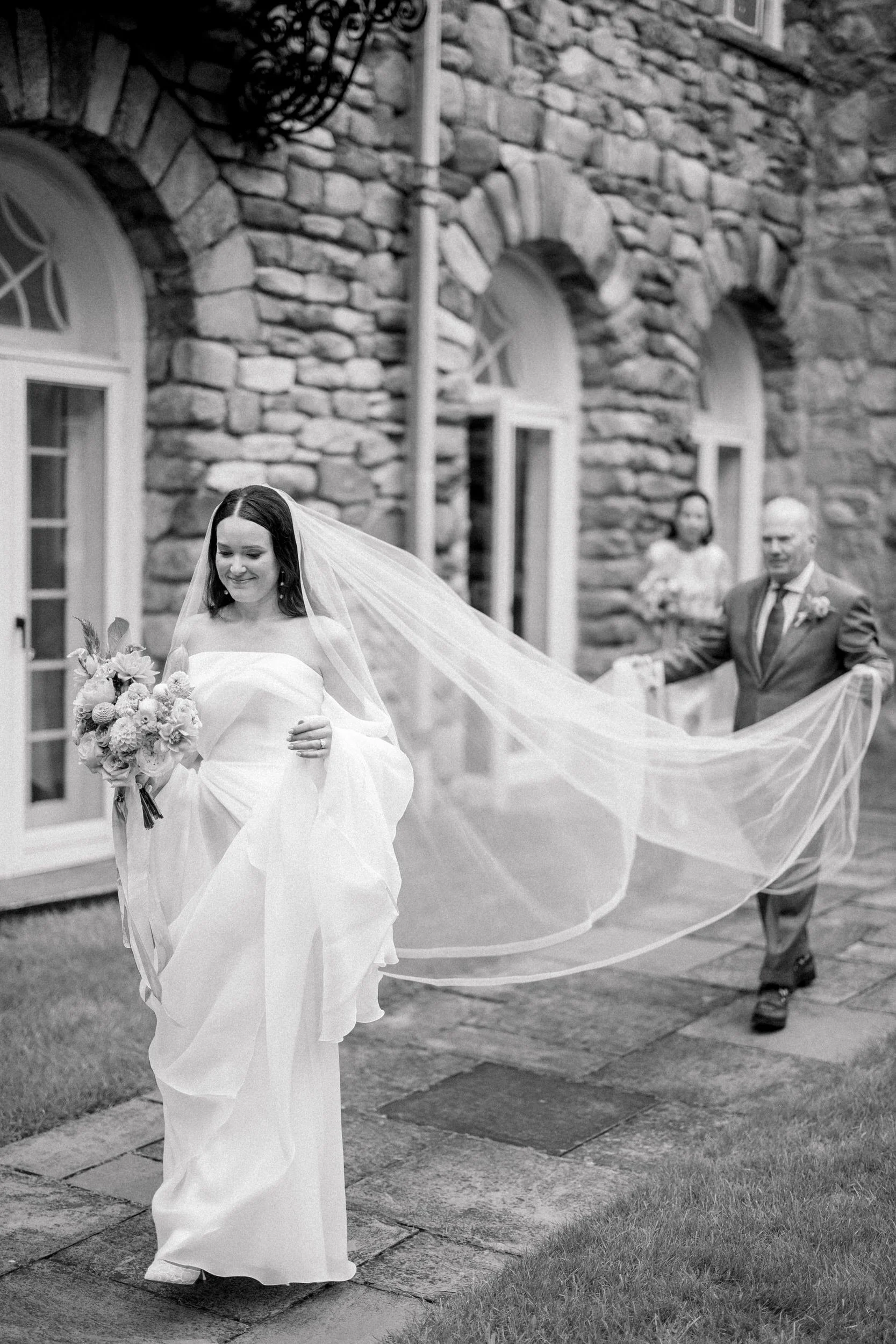 Bride walking down the aisle through a whimsical secret garden ceremony filled with colorful flowers.