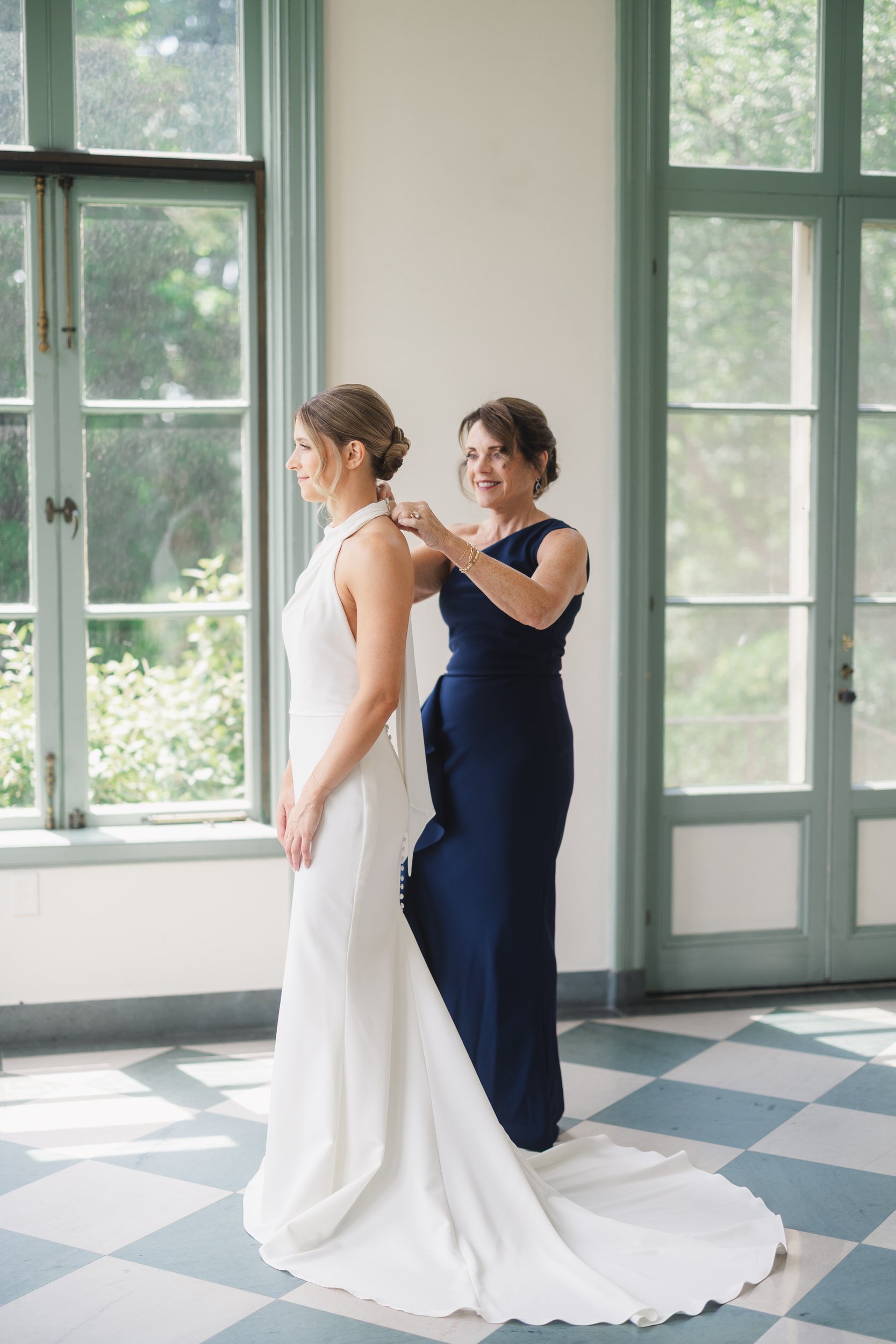 Bride having finishing touches applied before a coastal garden party wedding.