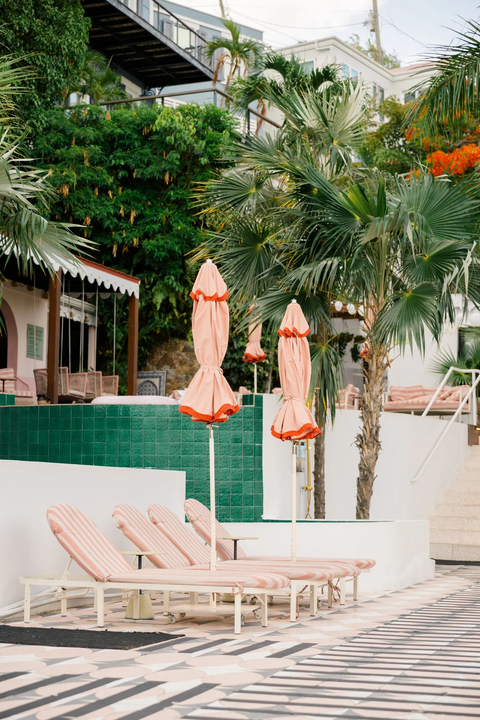 The Pink Palm Hotel pool surrounded by tropical greenery with views of St. Thomas