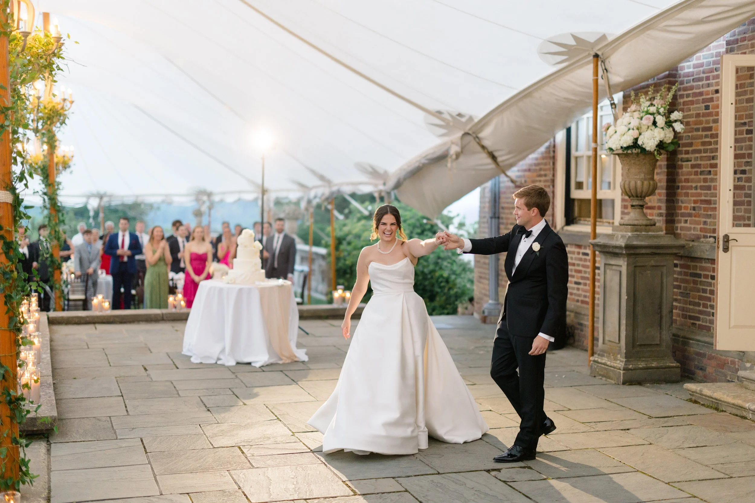 Newlyweds sharing their first dance during an elegant reception inside the sailcloth tent at Castle Hill on the Crane Estate in Ipswich, Massachusetts.