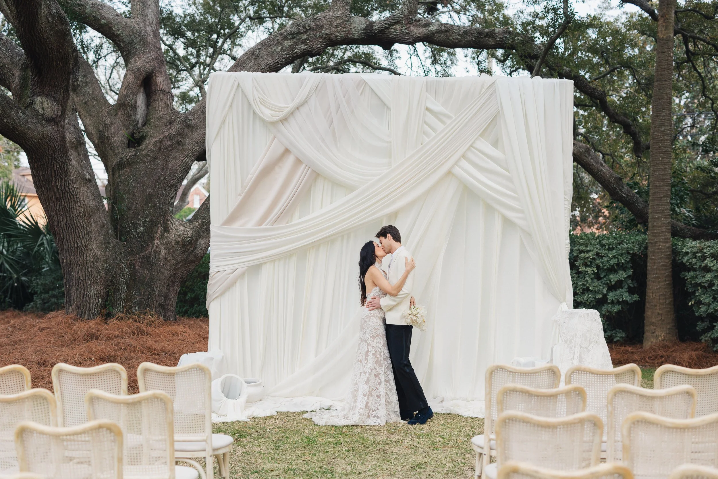 Bride and groom portraits in front of white ceremony drapery at Lowndes Grove