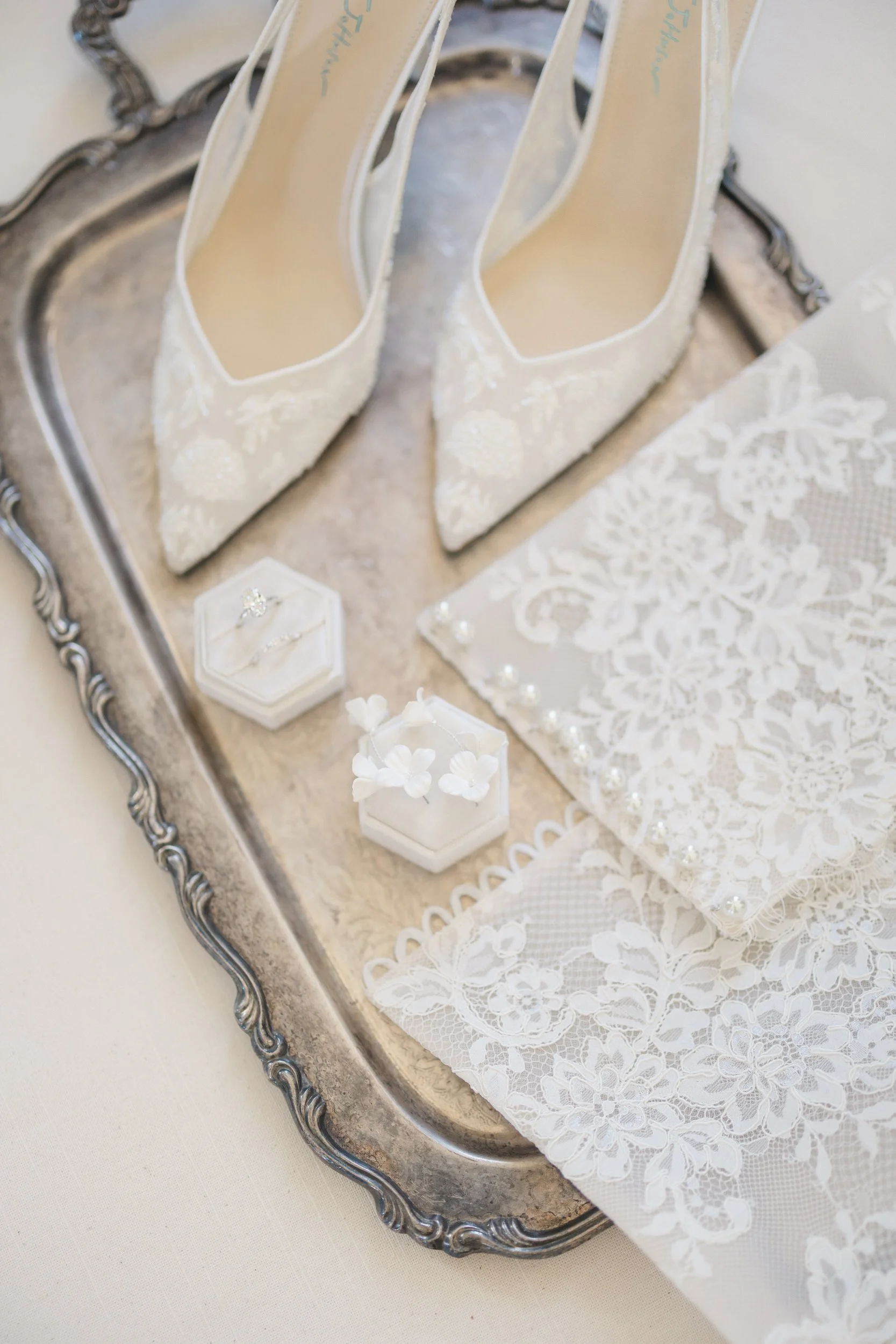 Neutral wedding day flat lay featuring bride’s accessories at Brasserie La Banque, Charleston, South Carolina
