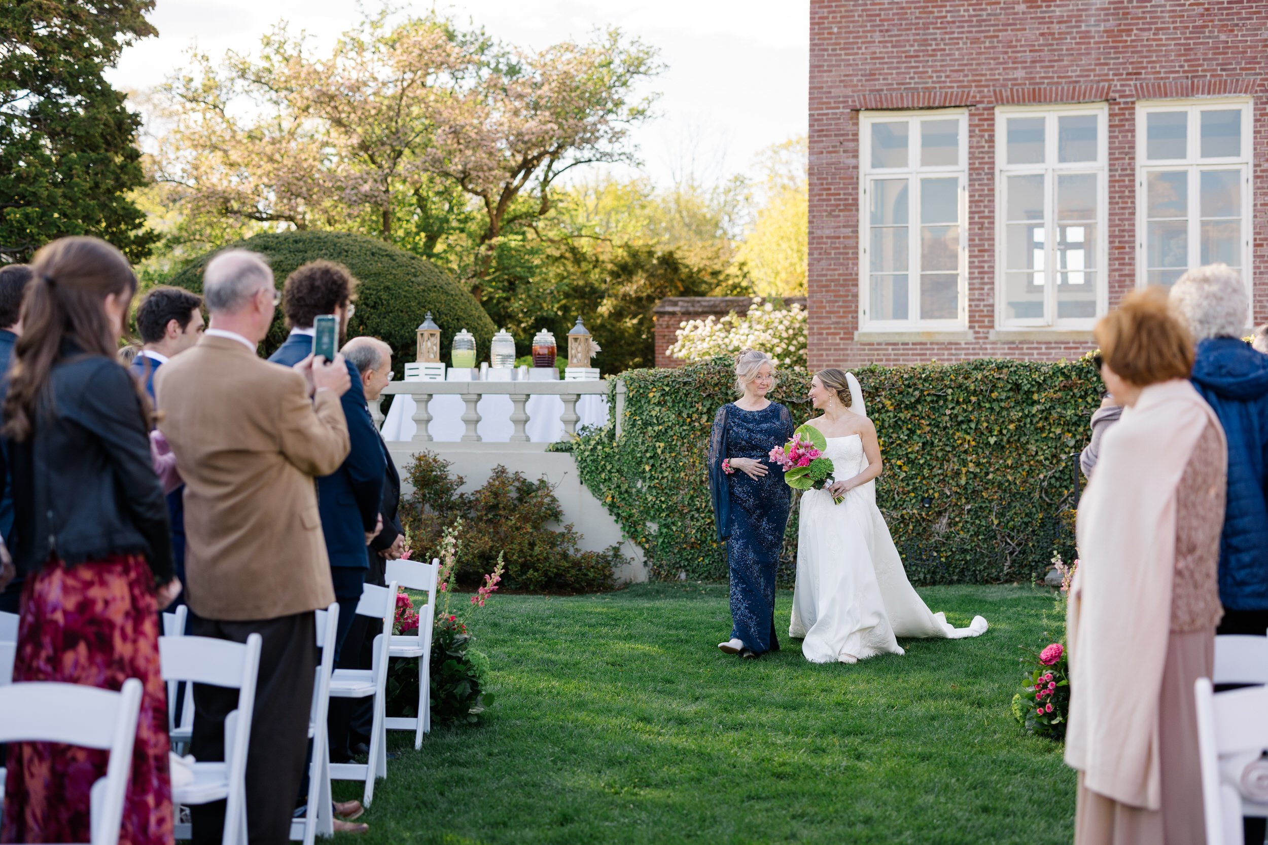 Modern oceanfront wedding ceremony with pink, mauve, and green florals