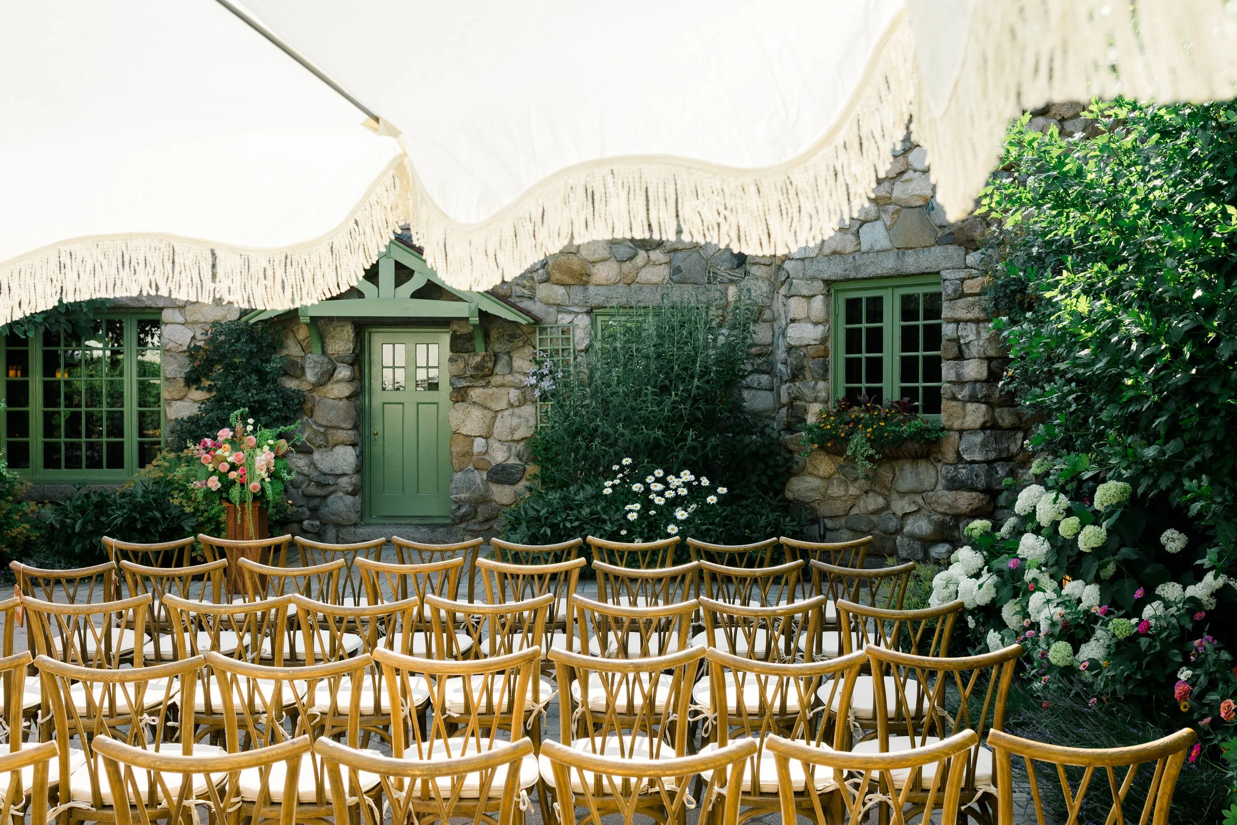 Colorful wedding ceremony setup with ranunculus anthuriums and amaranthus at Massachusetts estate venue
