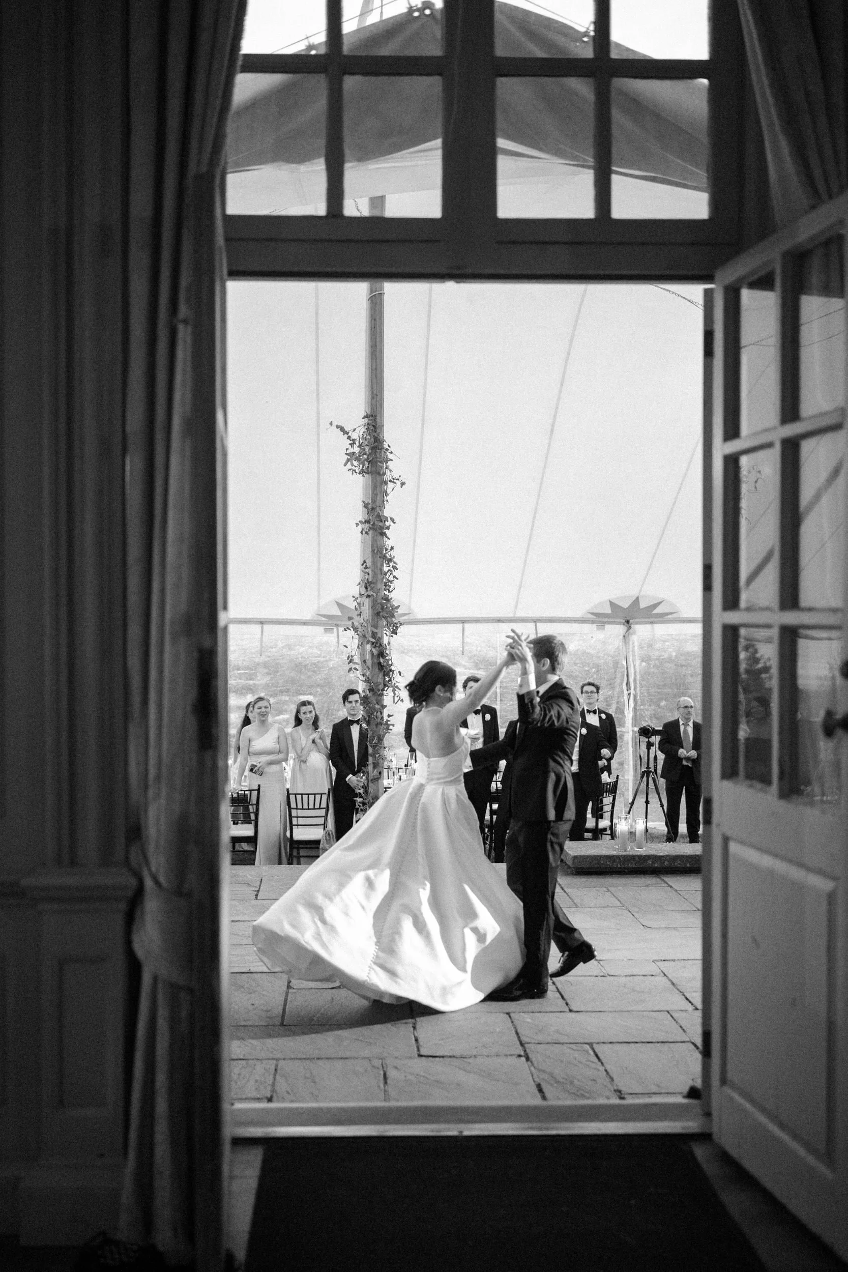 Newlyweds sharing their first dance during an elegant reception inside the sailcloth tent at Castle Hill on the Crane Estate in Ipswich, Massachusetts.