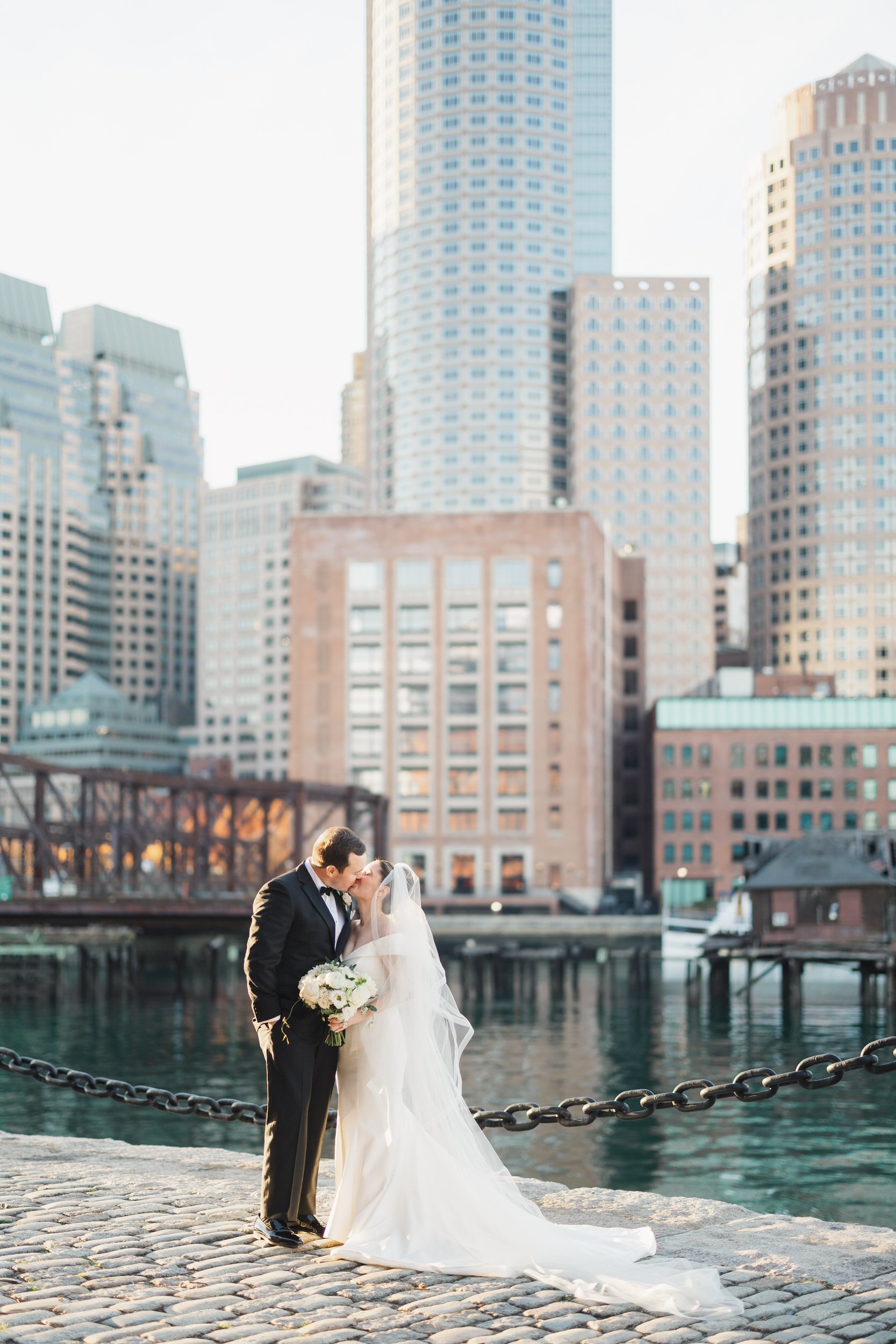 Sunset wedding portraits at Fan Pier Park with Boston skyline views