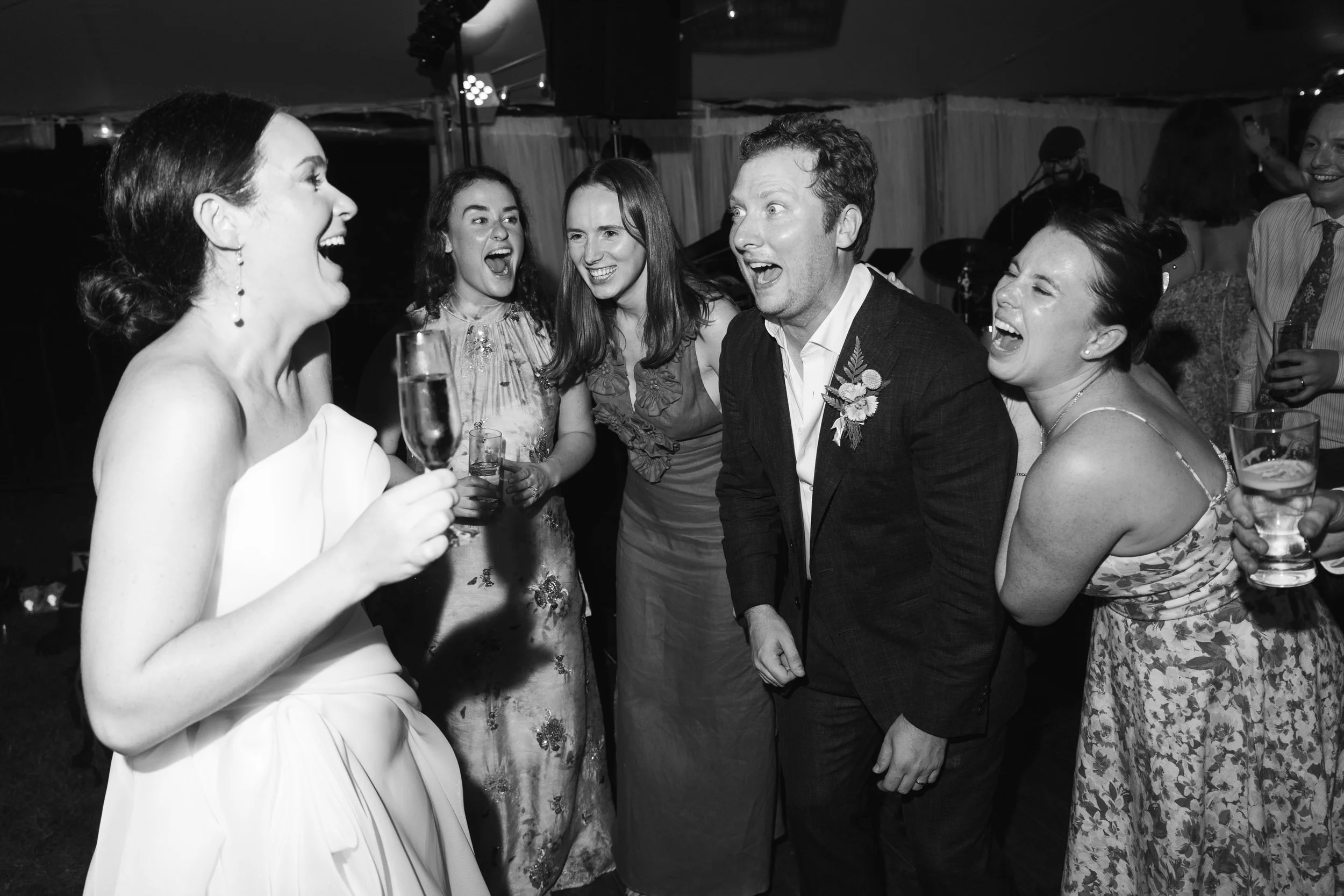 Guests dancing beneath colorful floral installations and full-scale trees at the reception.