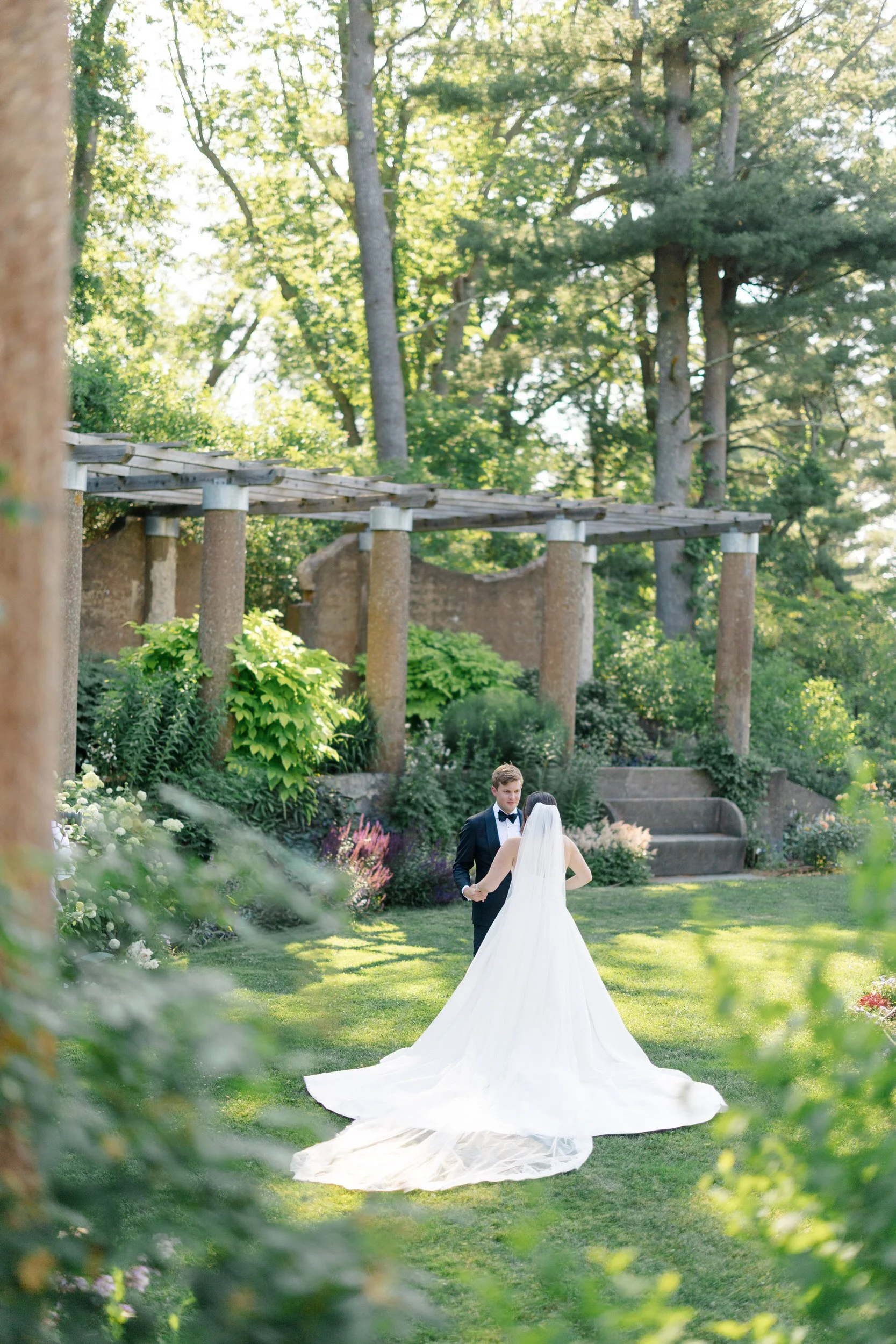 Emotional wedding day first look surrounded by lush blooms at Castle Hill in Ipswich.