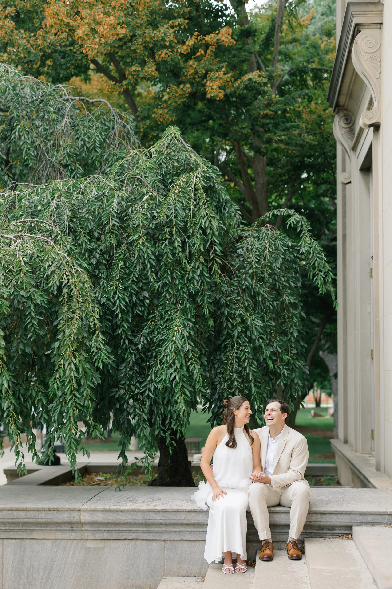 Couple embracing beneath marble columns during a classic Boston engagement session.
