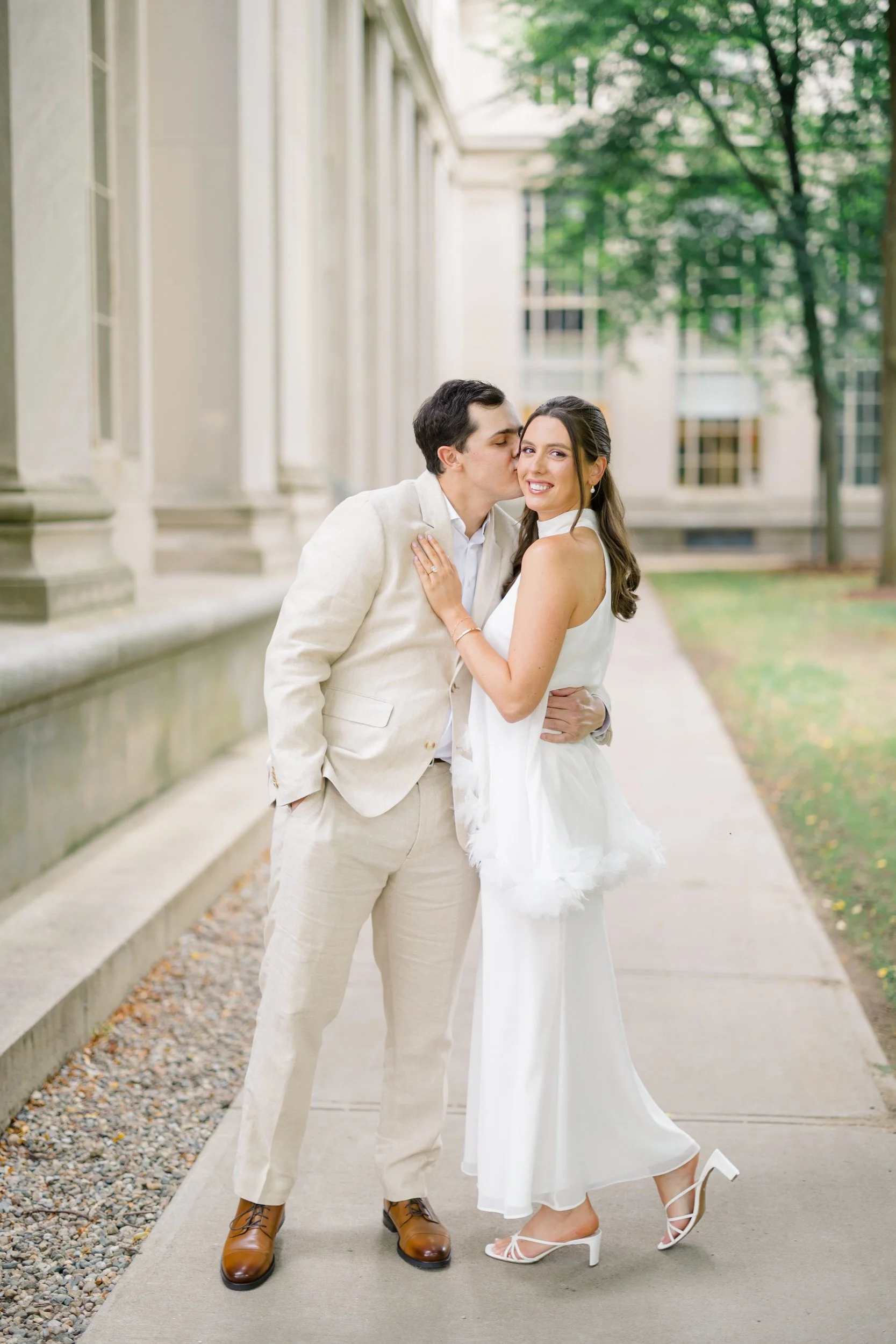 Couple beneath grand marble columns during a timeless Cambridge engagement session.