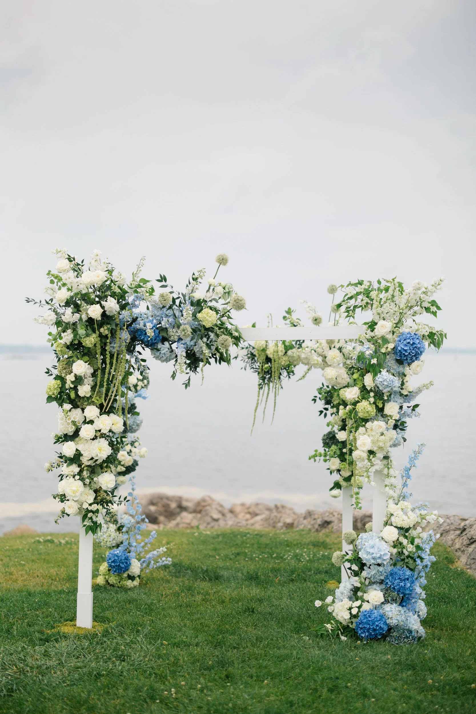 Coastal wedding ceremony details at Chandler Hovey Park with florals inspired by New England’s sail-filled harbor views.