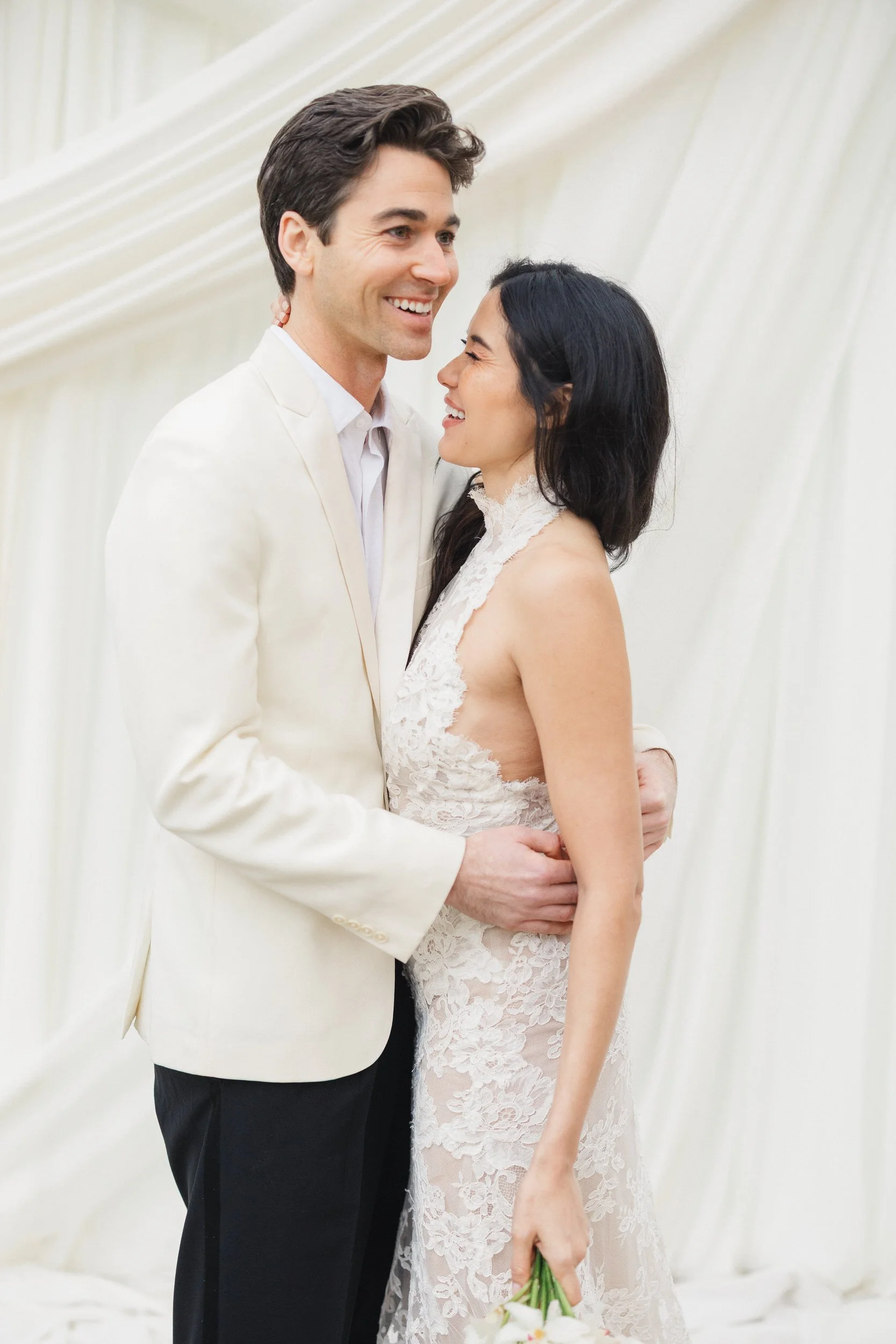 Bride and groom standing beneath white ceremony draping at Lowndes Grove