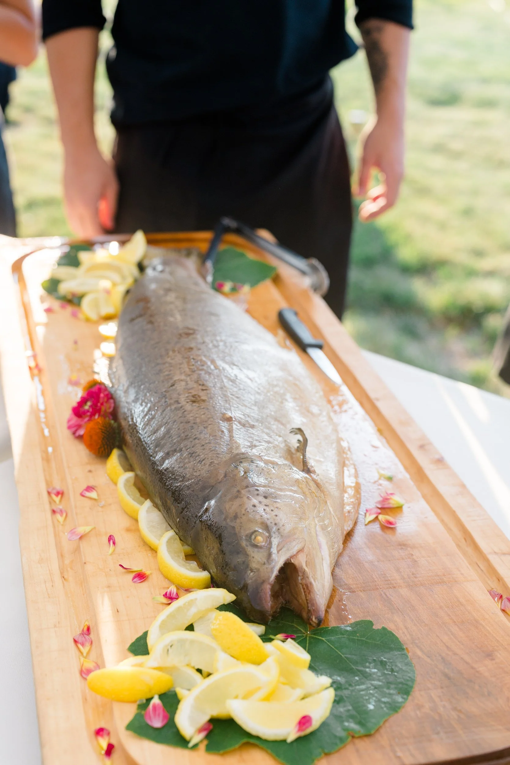 Wedding guests sharing a meal catered by Smoke and Pickles Catering Co. at a Cape Cod private estate.