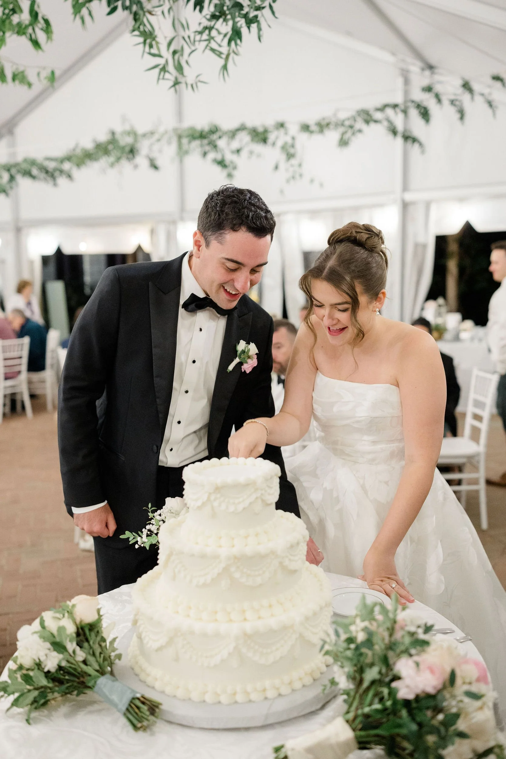 Newlyweds cutting their wedding cake at Long Hill in Beverly, Massachusetts.