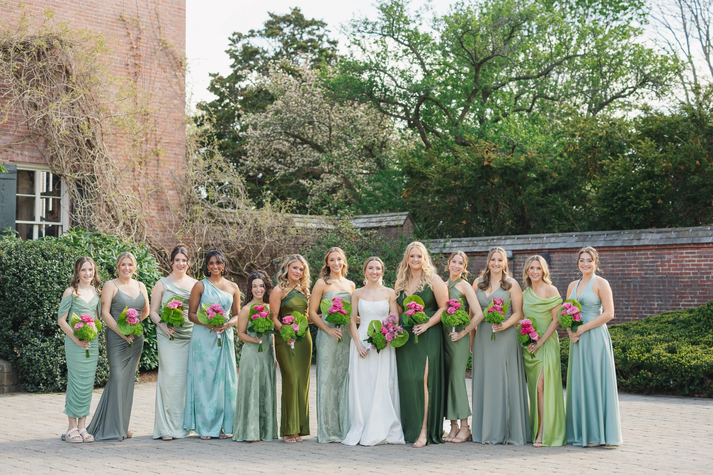 Modern bridesmaids portraits with green, pink, and mauve bouquets