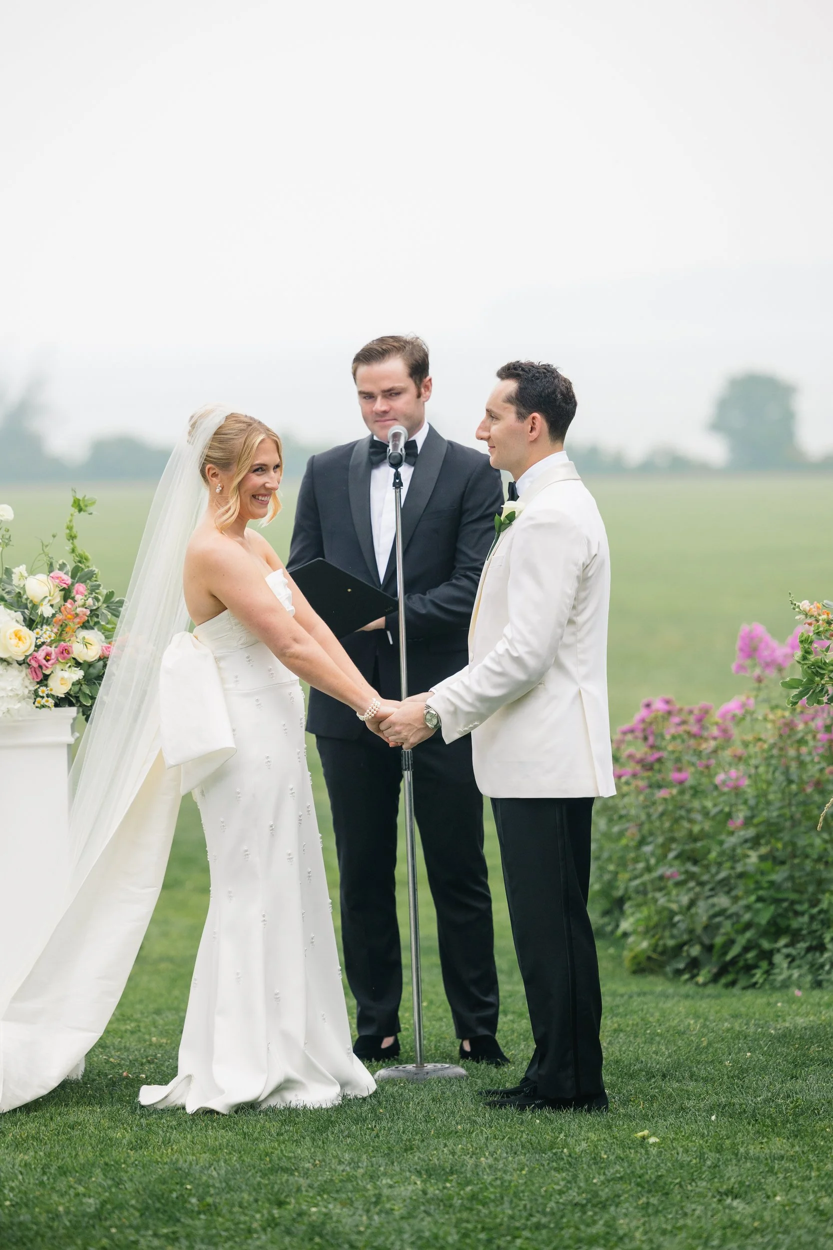 Couple saying "I do" during a romantic rainy ceremony in the gardens.