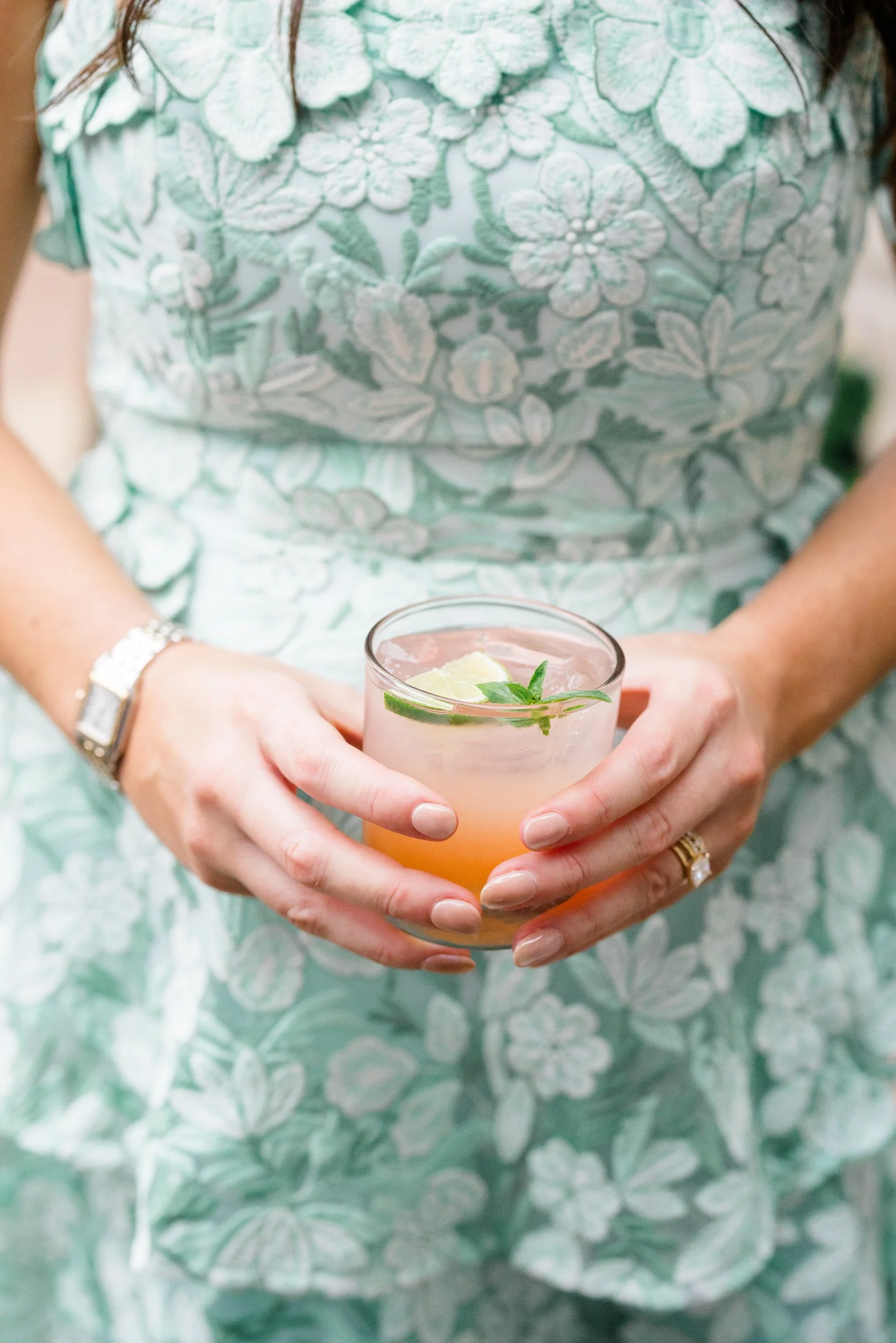 Guests mingling among bright pink, orange, yellow, coral, and red flowers during cocktail hour.