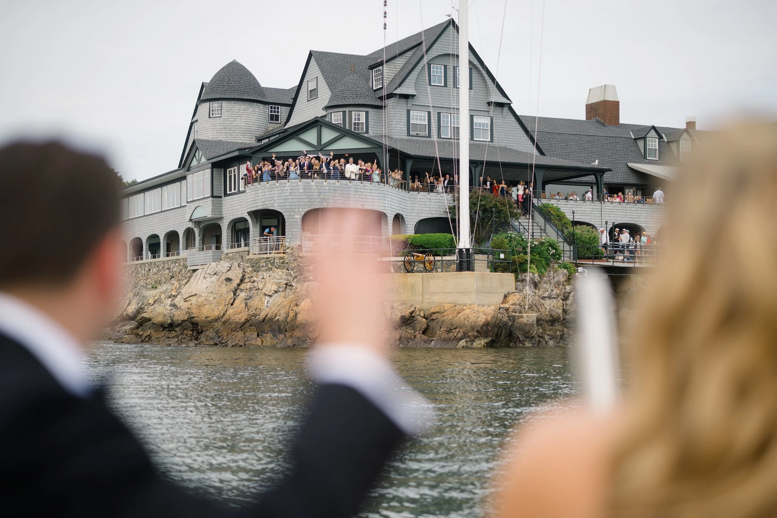 Cocktail hour overlooking Marblehead Harbor at Corinthian Yacht Club during a coastal wedding celebration.