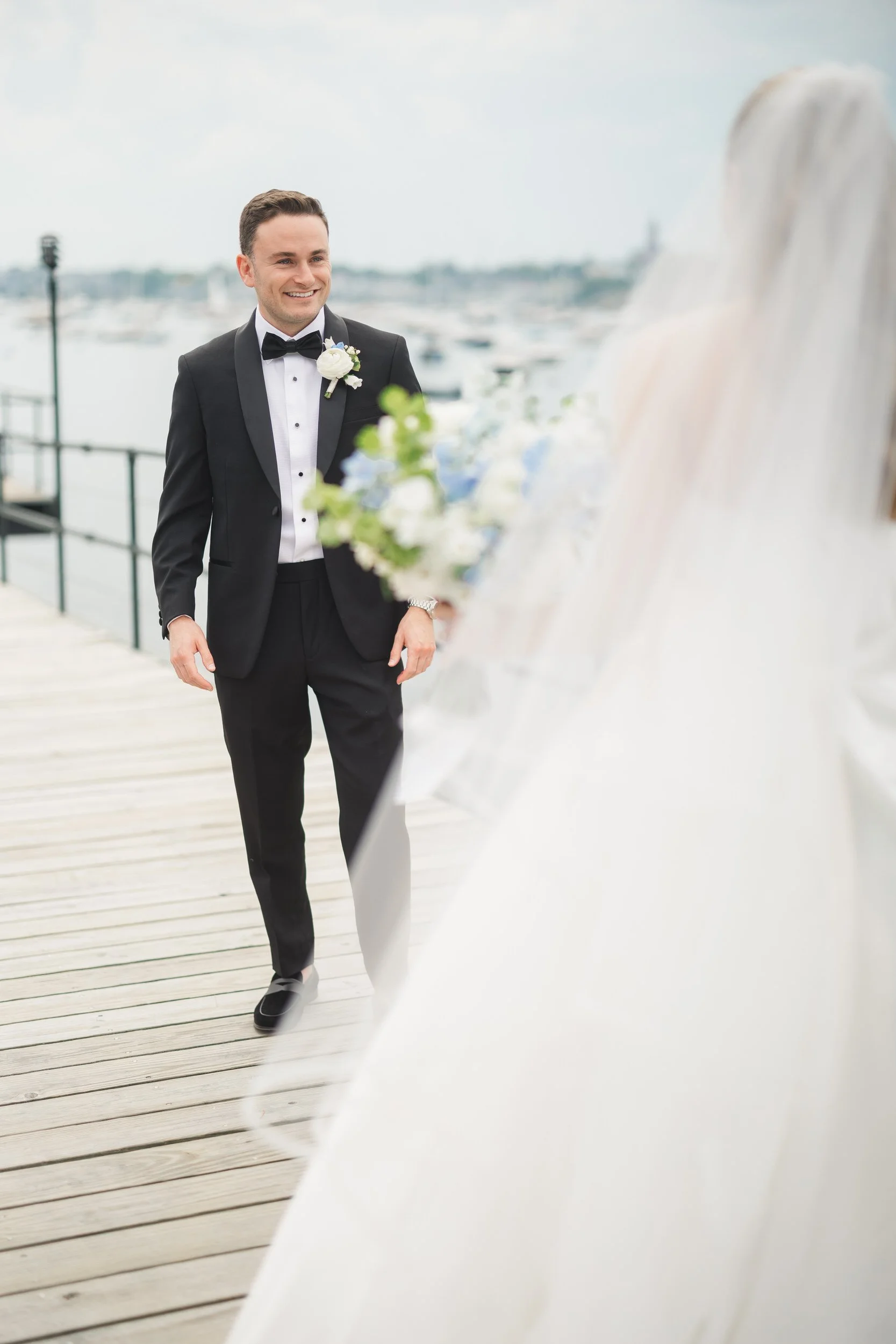 A timeless first look on the docks of Corinthian Yacht Club during a coastal New England wedding.