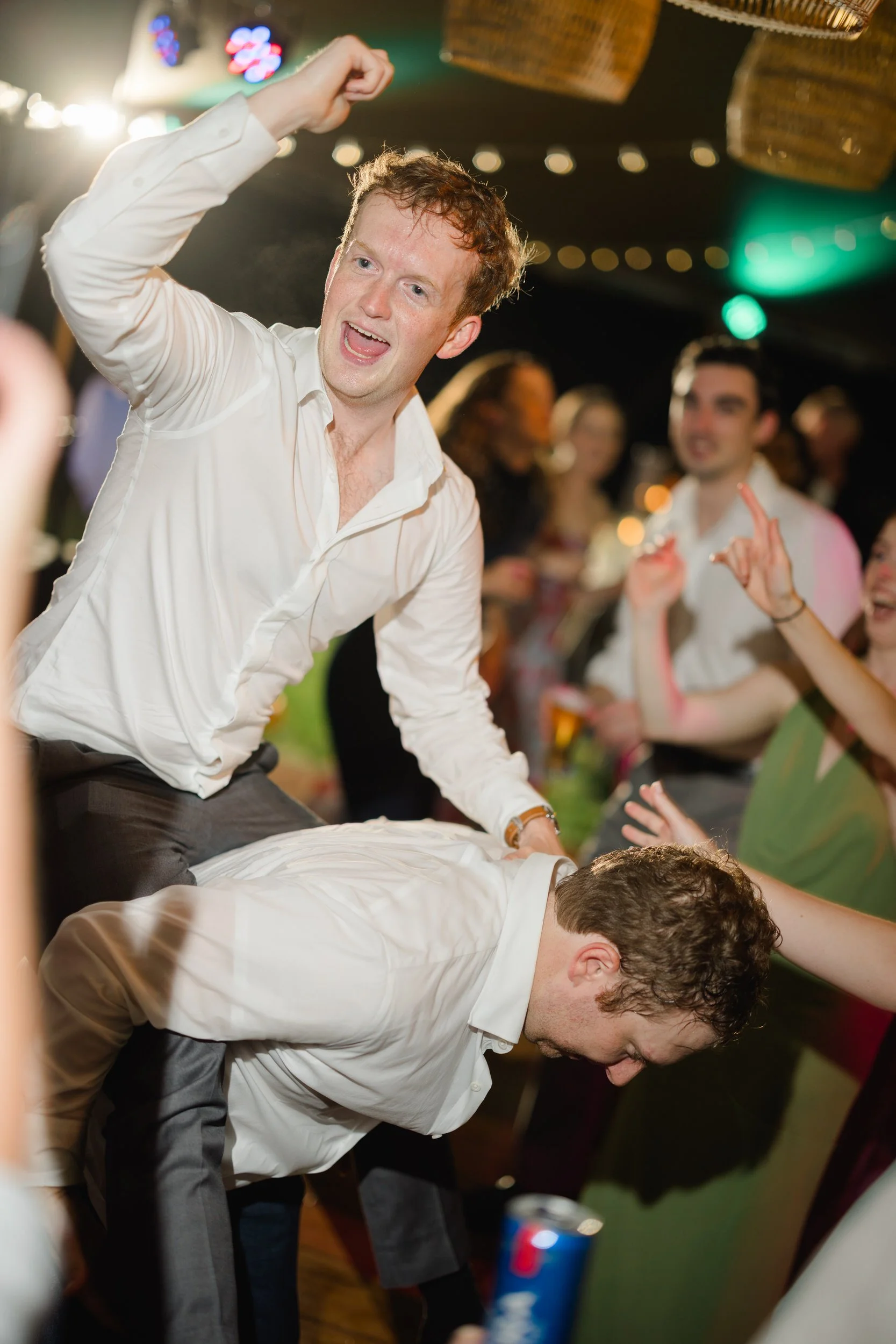 Joyful wedding guests dancing among lush colorful floral installations.