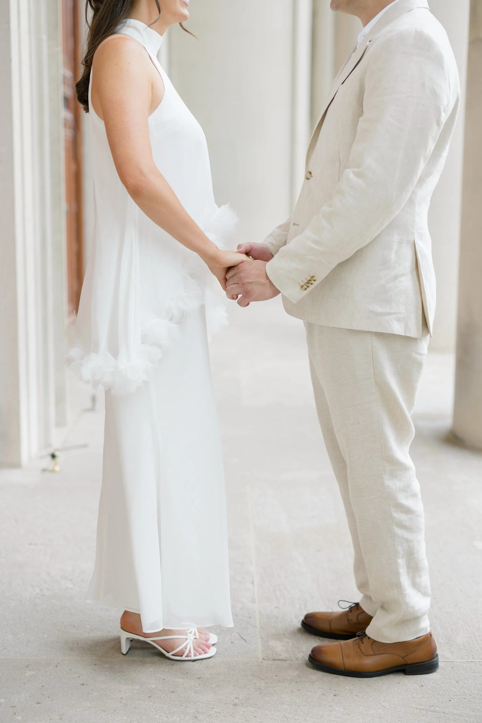 Couple embracing beneath marble columns during a classic Boston engagement session.