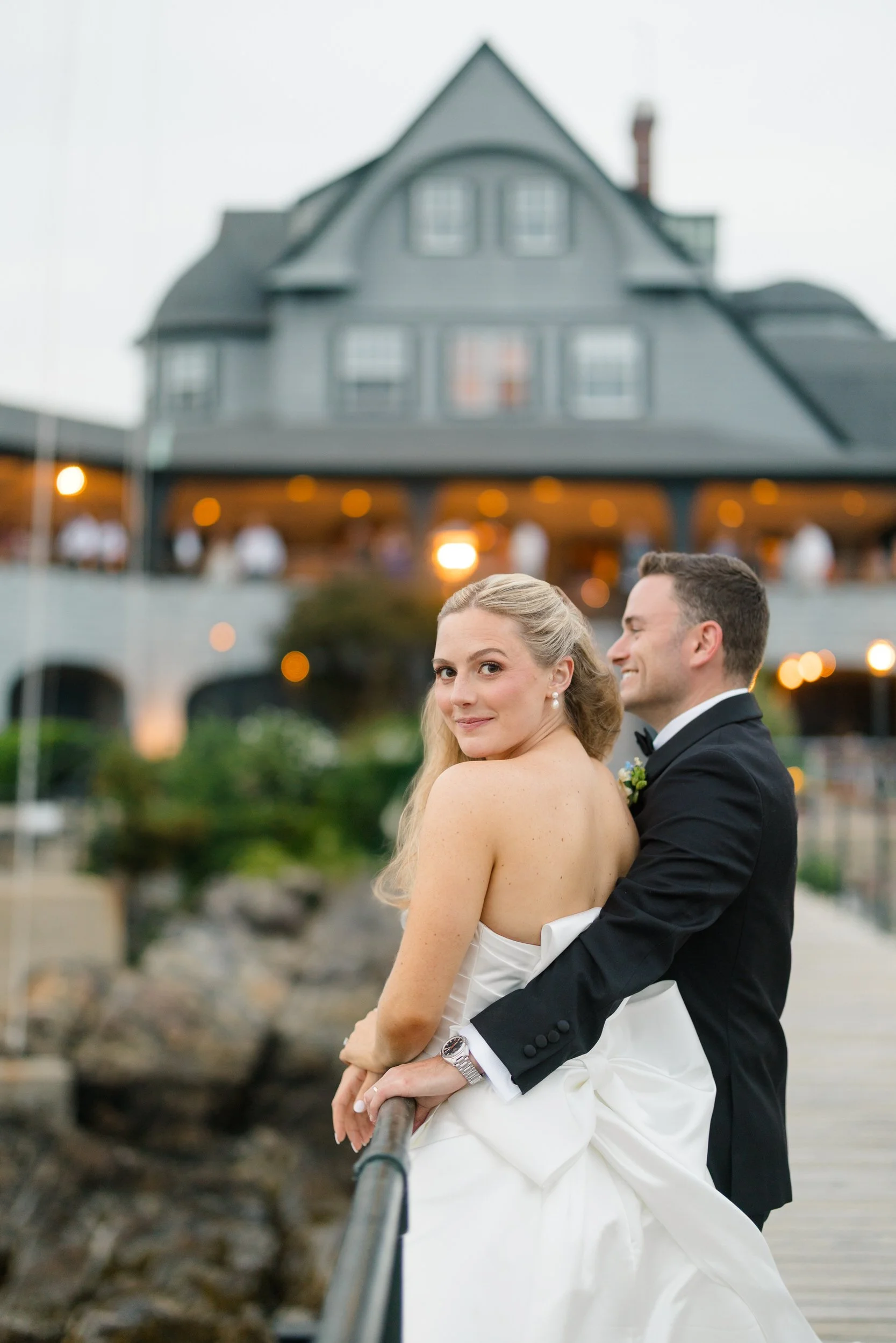 Golden hour couple portraits with sailboats filling the harbor during a Marblehead wedding.