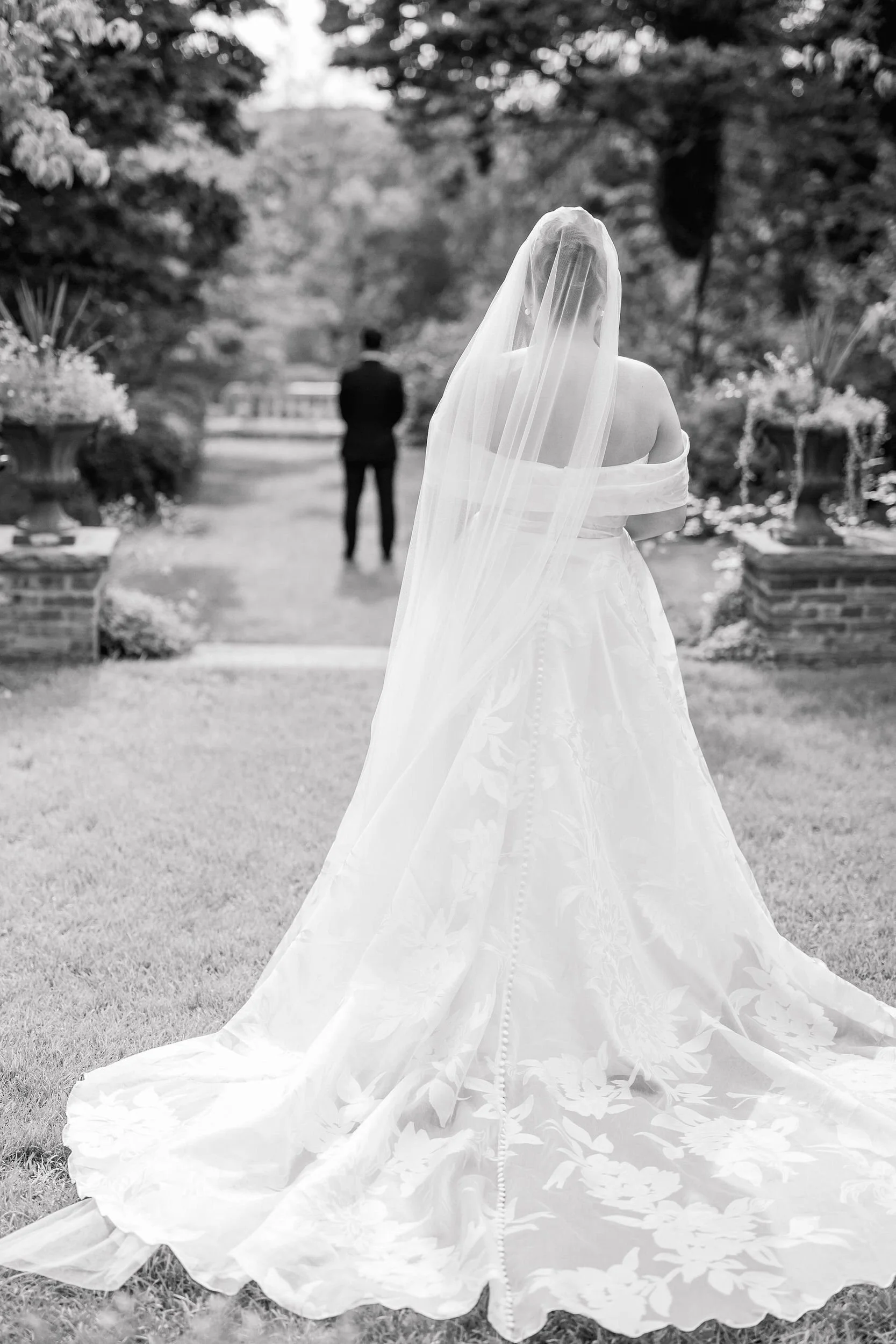 Wedding couple sharing their first look in the gardens at Long Hill in Beverly, Massachusetts.