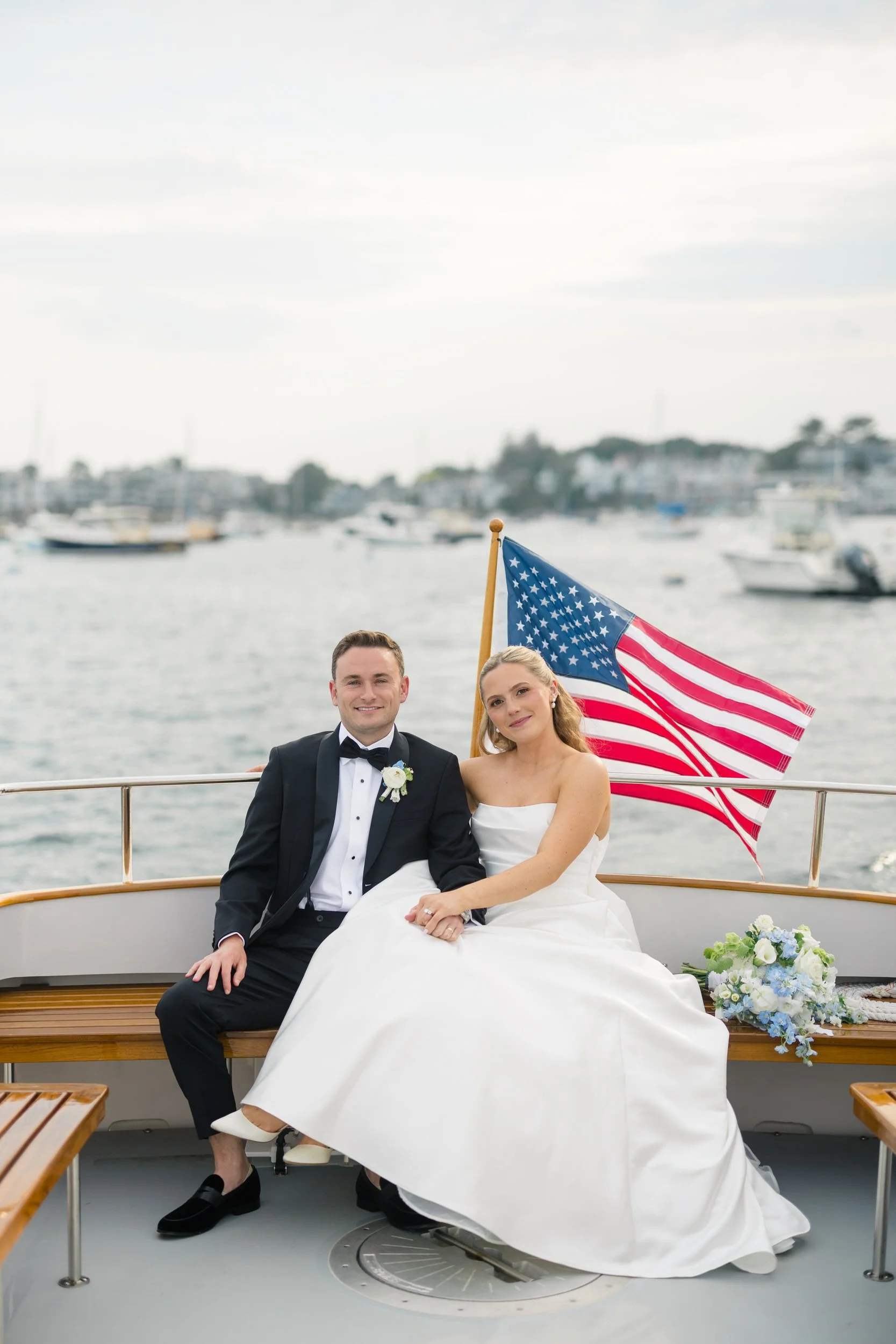 Couple traveling by boat between ceremony and reception during a coastal New England wedding at Corinthian Yacht Club.