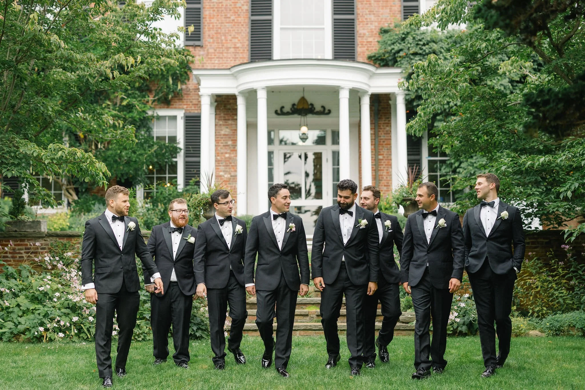 Groomsmen laughing together during an outdoor wedding in Massachusetts.