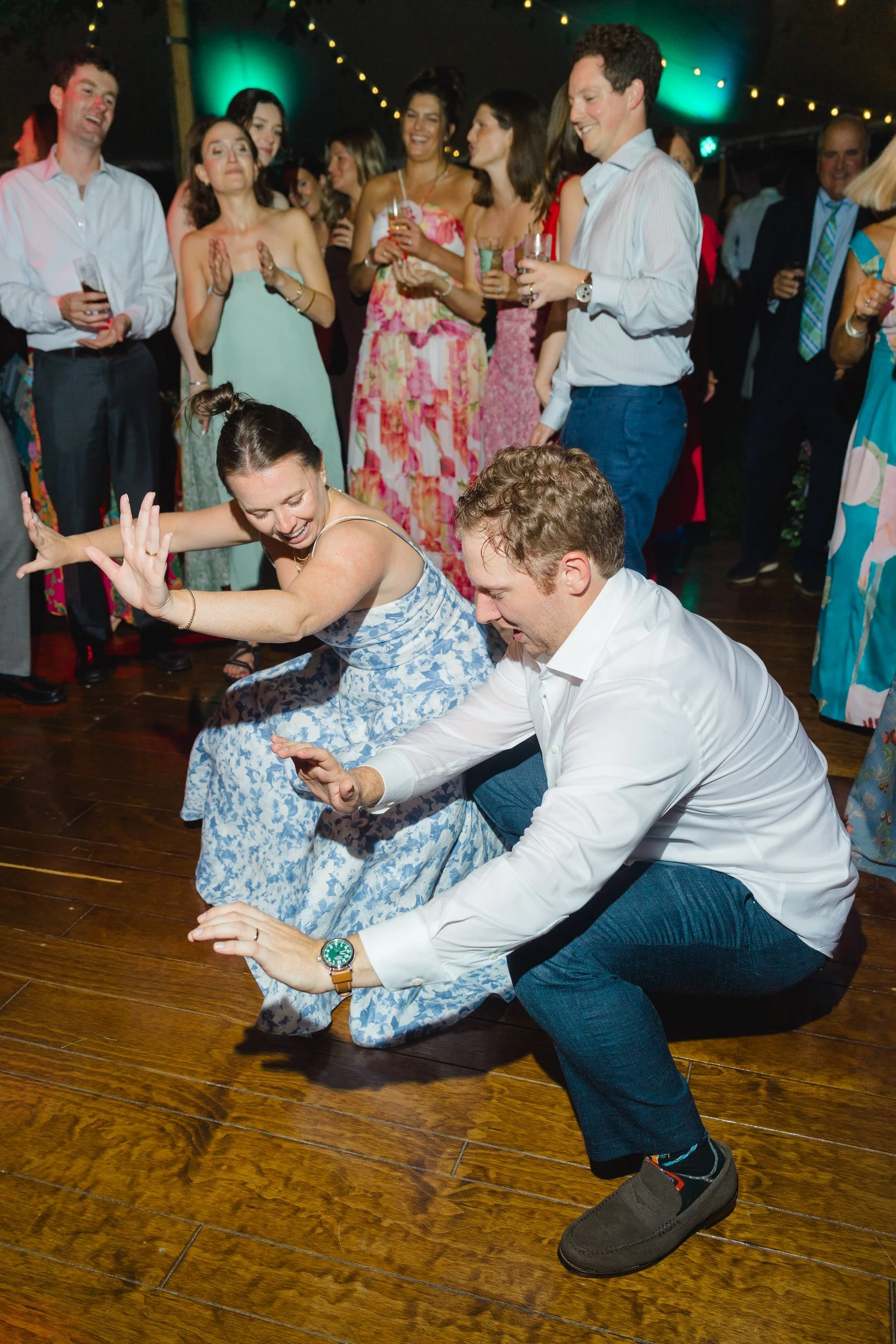 Joyful wedding guests dancing among lush colorful floral installations.