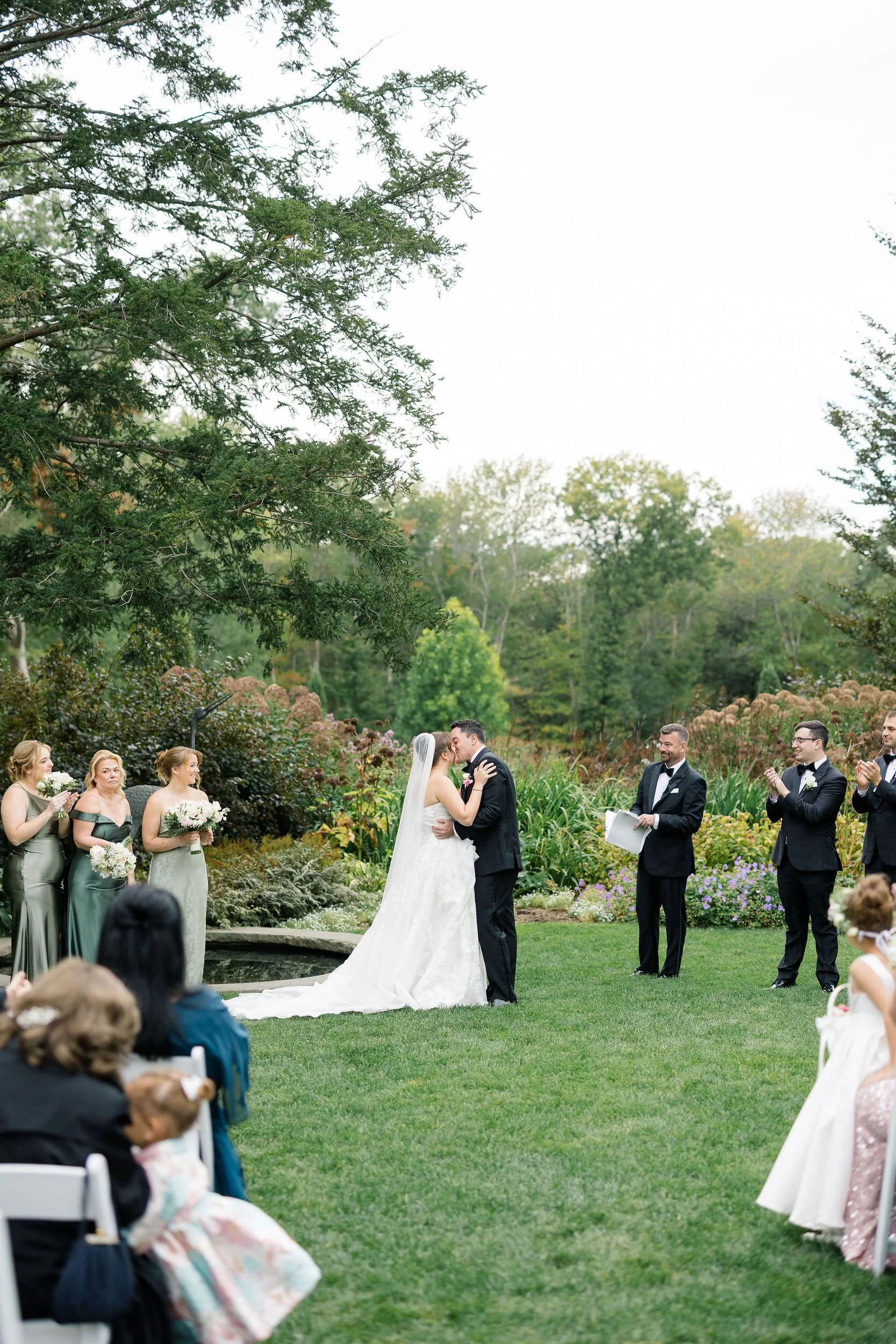 Couple sharing their first kiss as newlyweds at Long Hill.