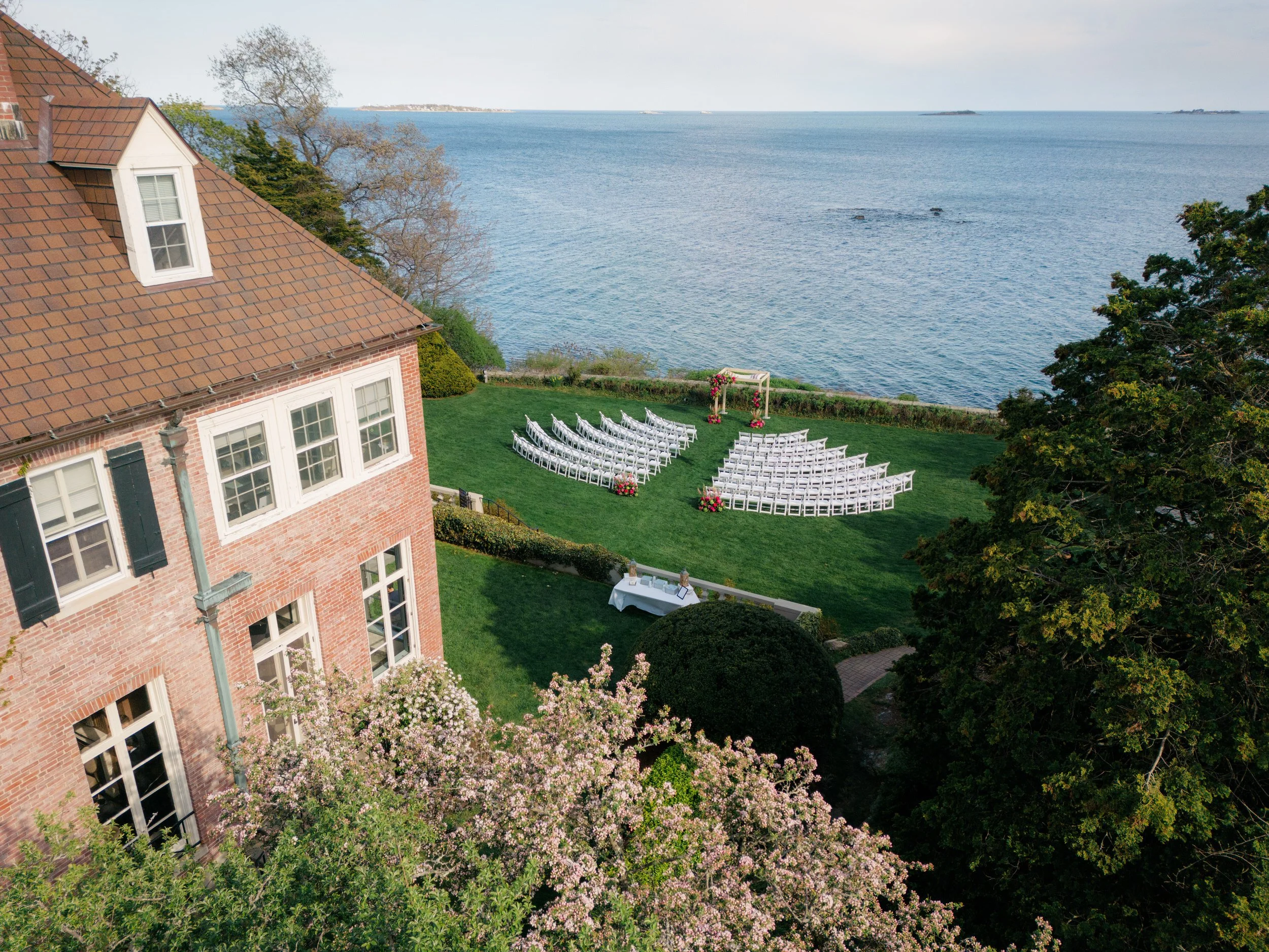 Oceanfront wedding ceremony at Misselwood Estate with green and pink florals