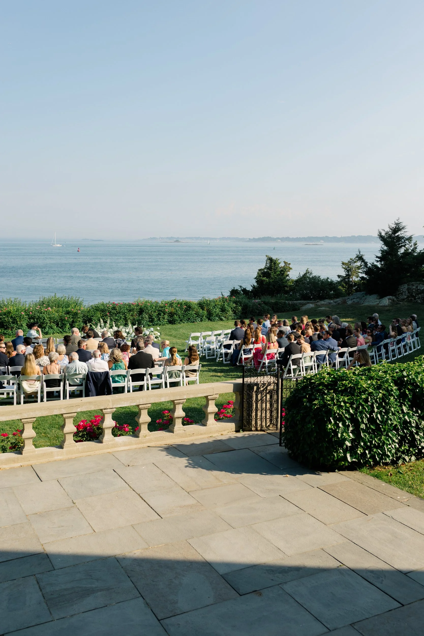 Guests watching the ceremony beneath clear summer skies.