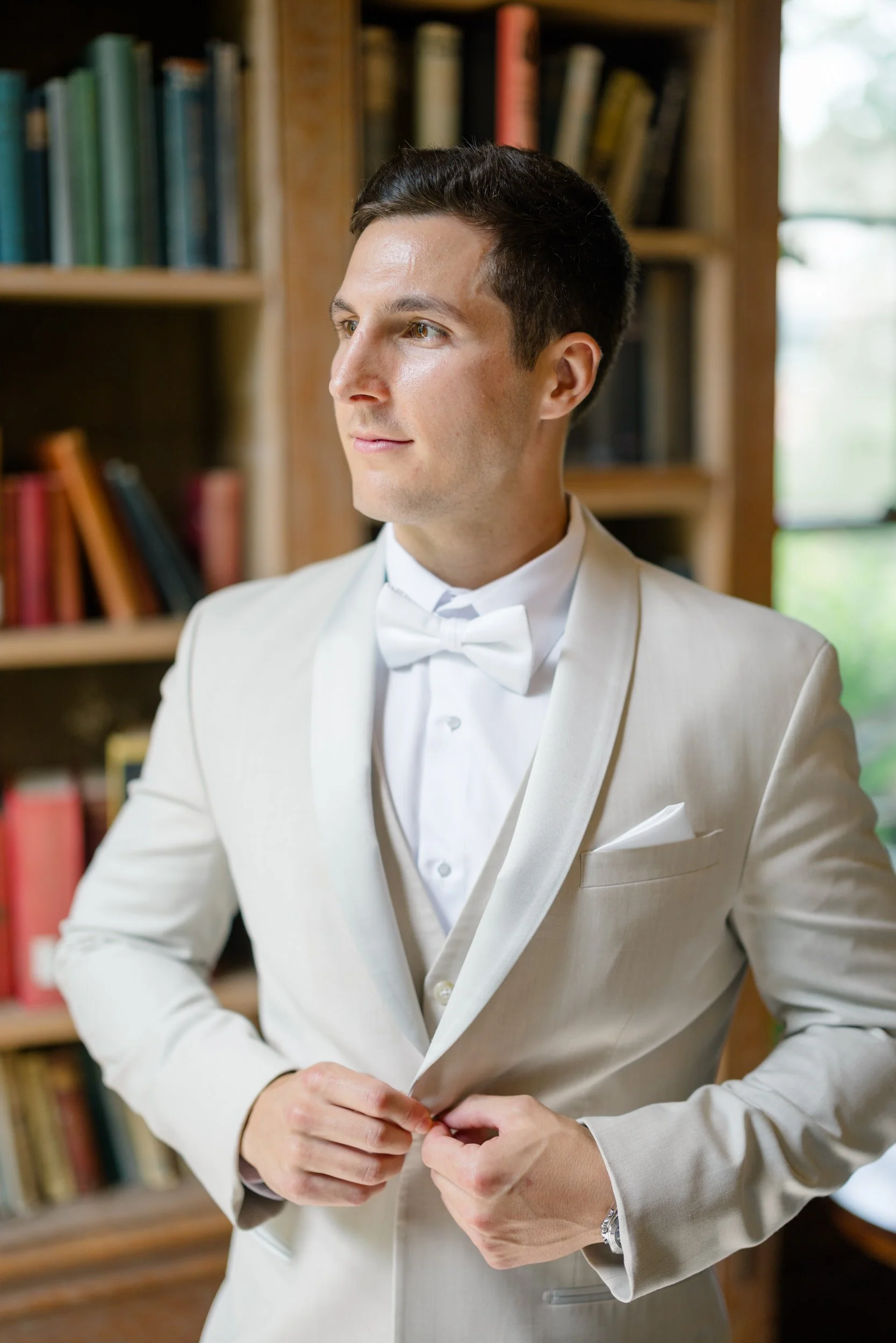 Groom adjusting his suite before a summer wedding at Misselwood Estate.