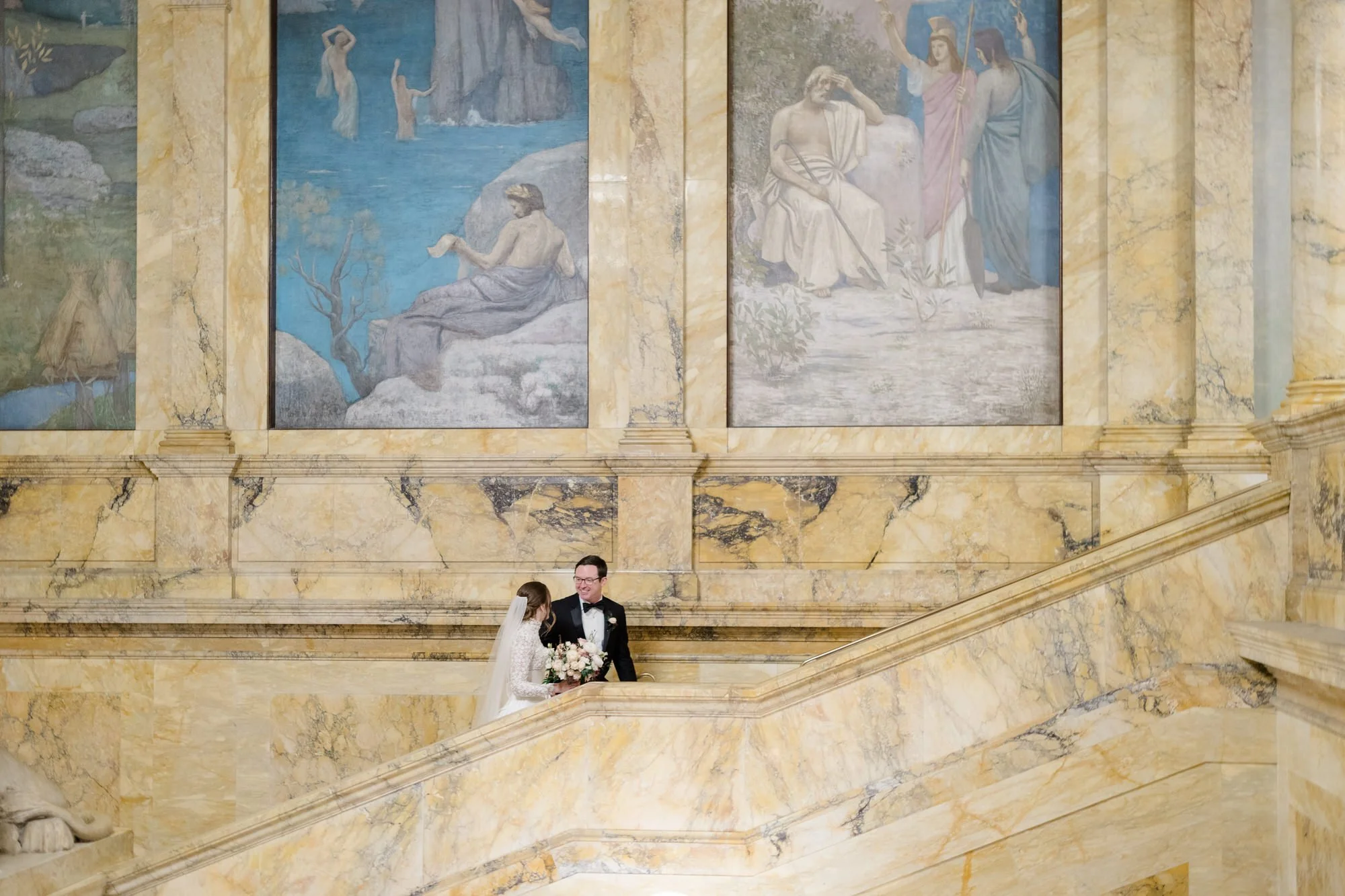 Couple walk hand in hand up stairs at Boston Public Library Wedding