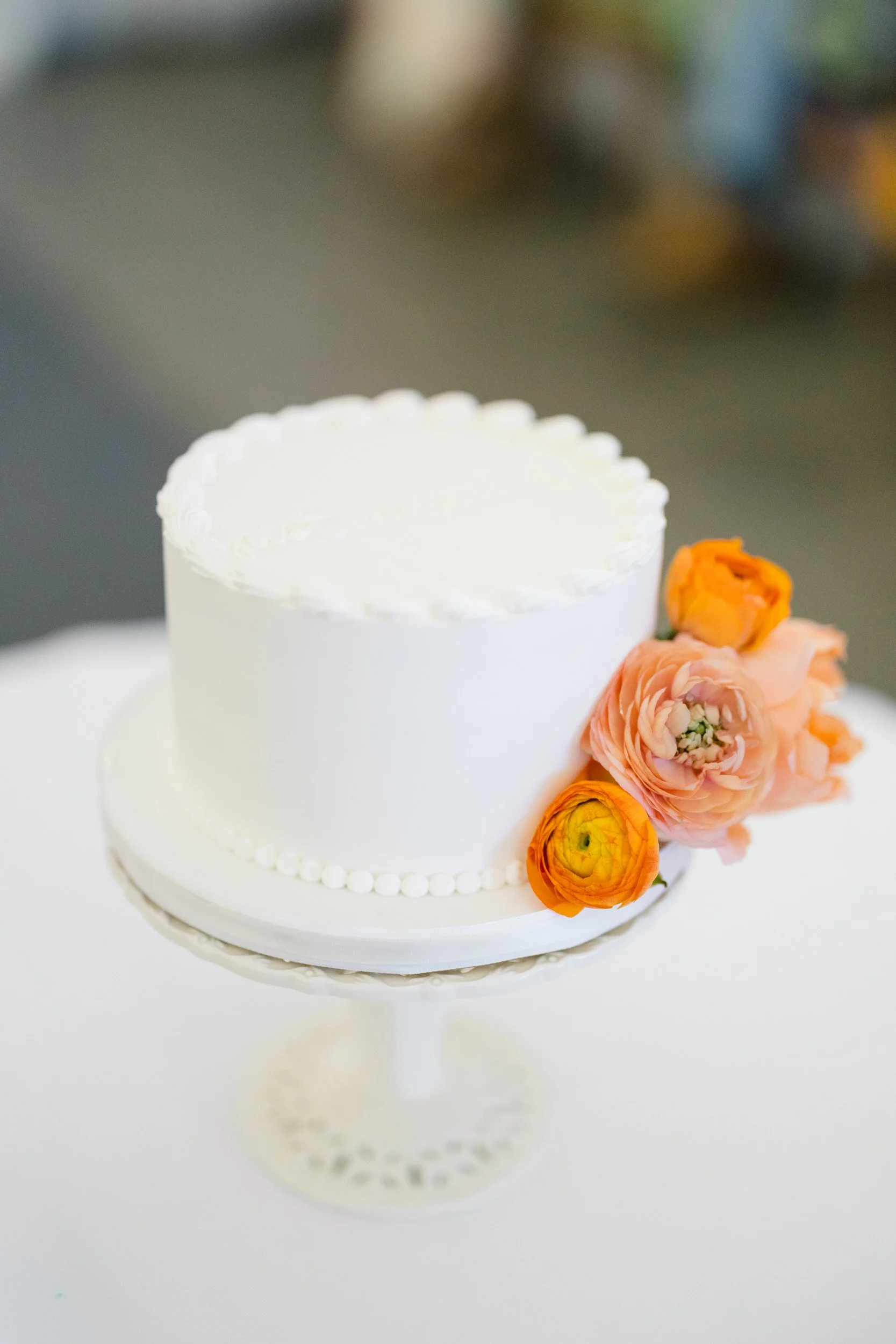 Elegant wedding cake displayed inside Blithewold Mansion.